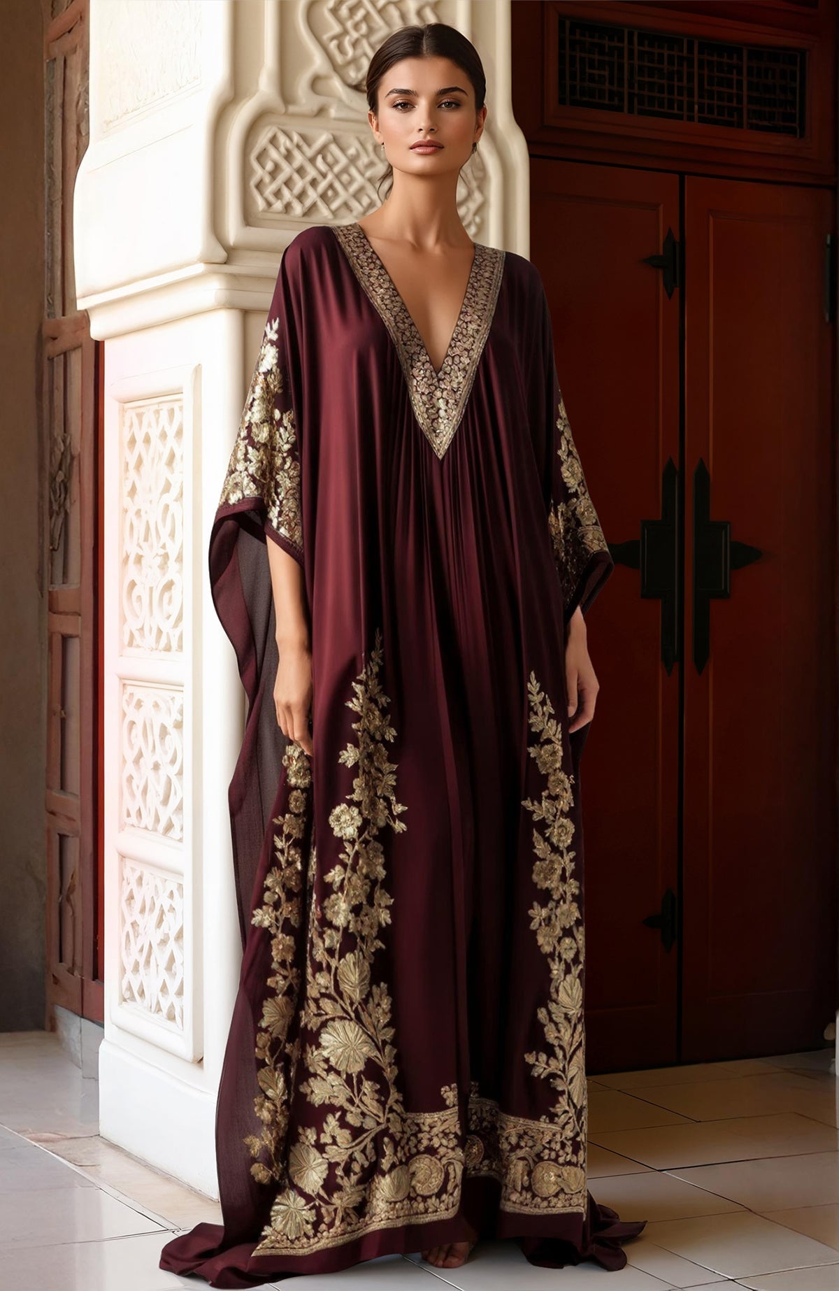 Deep burgundy kaftan with gold Kashmiri tilla embroidery and wide draped sleeves.
