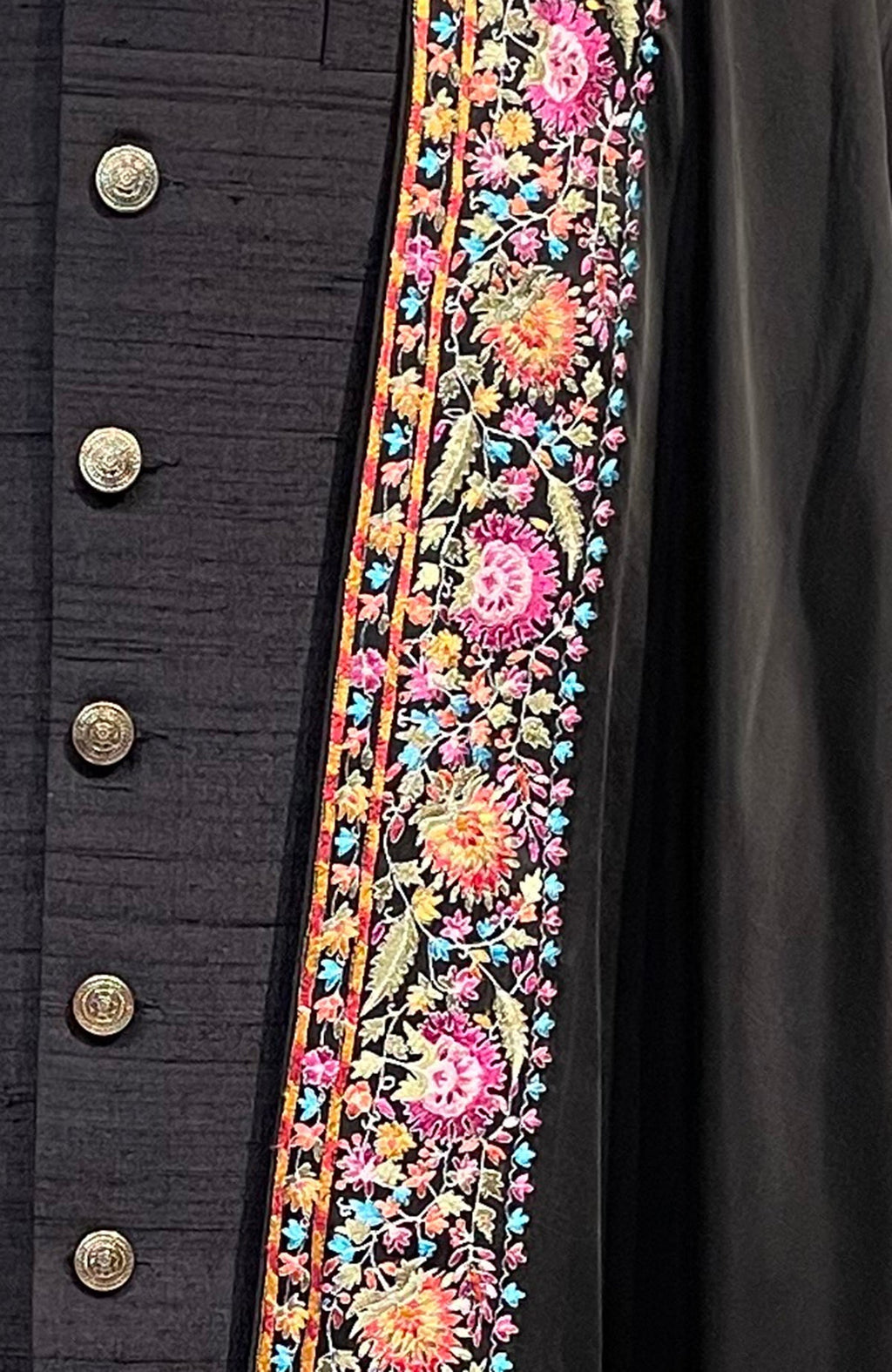 Black shawl with colorful floral embroidery and gold buttons.