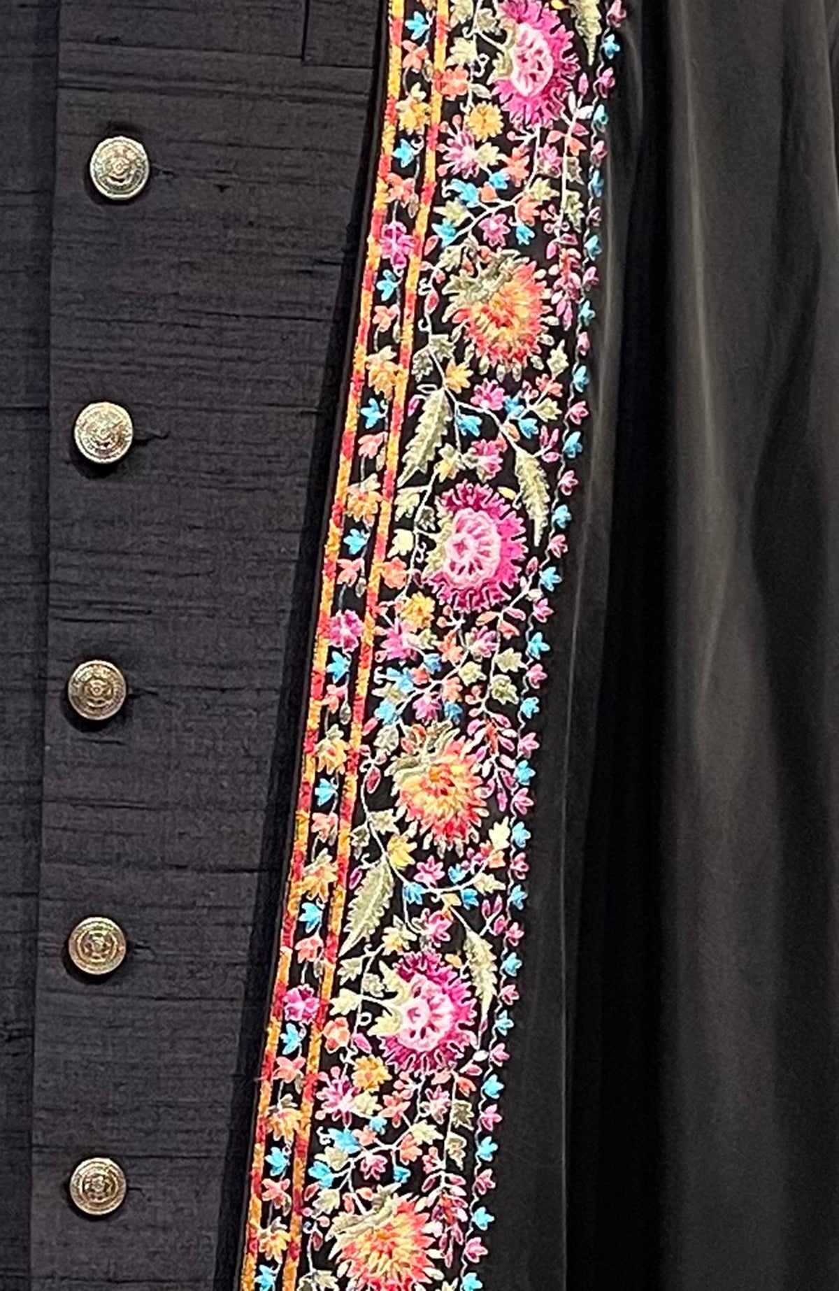 Black shawl with colorful floral embroidery and gold buttons.