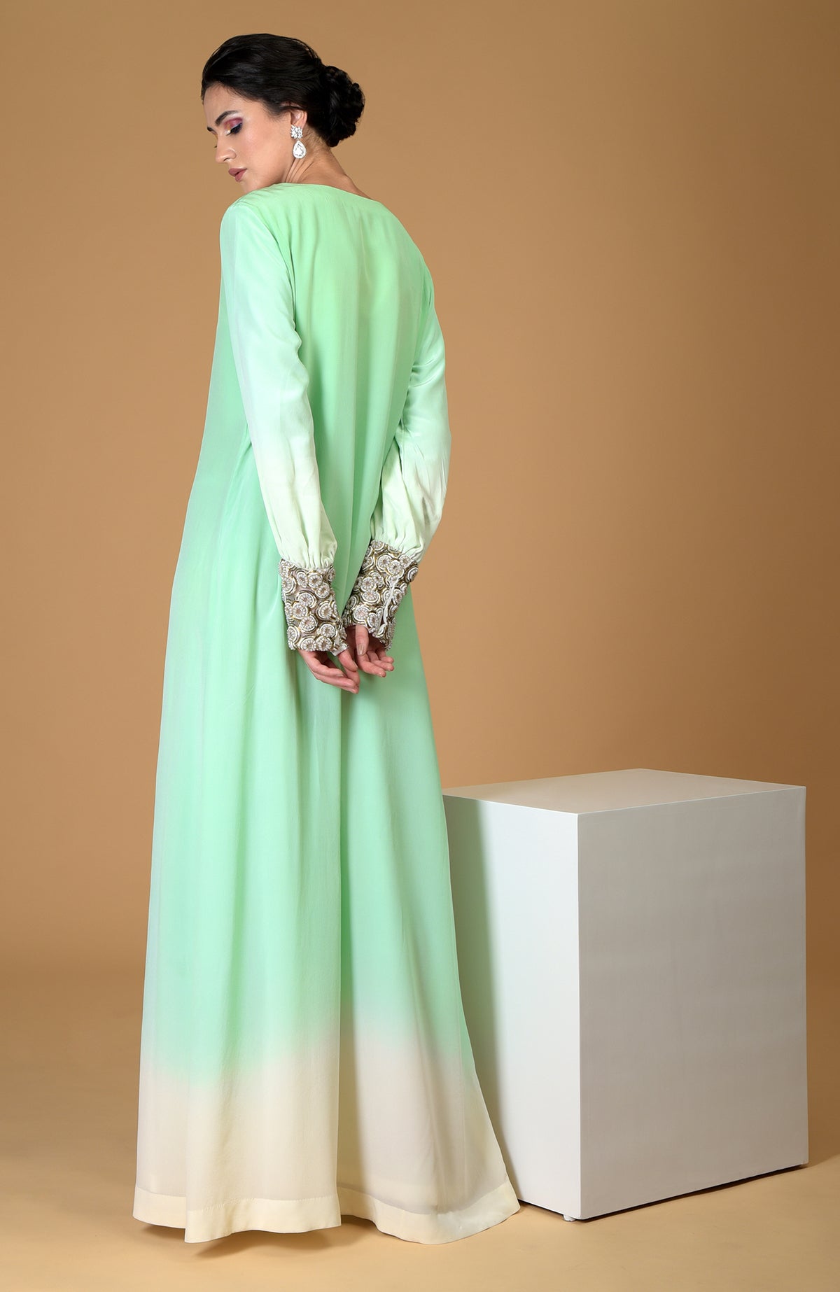 Ombre sage green silk crepe gown with sparkling circular jewelled cuffs.