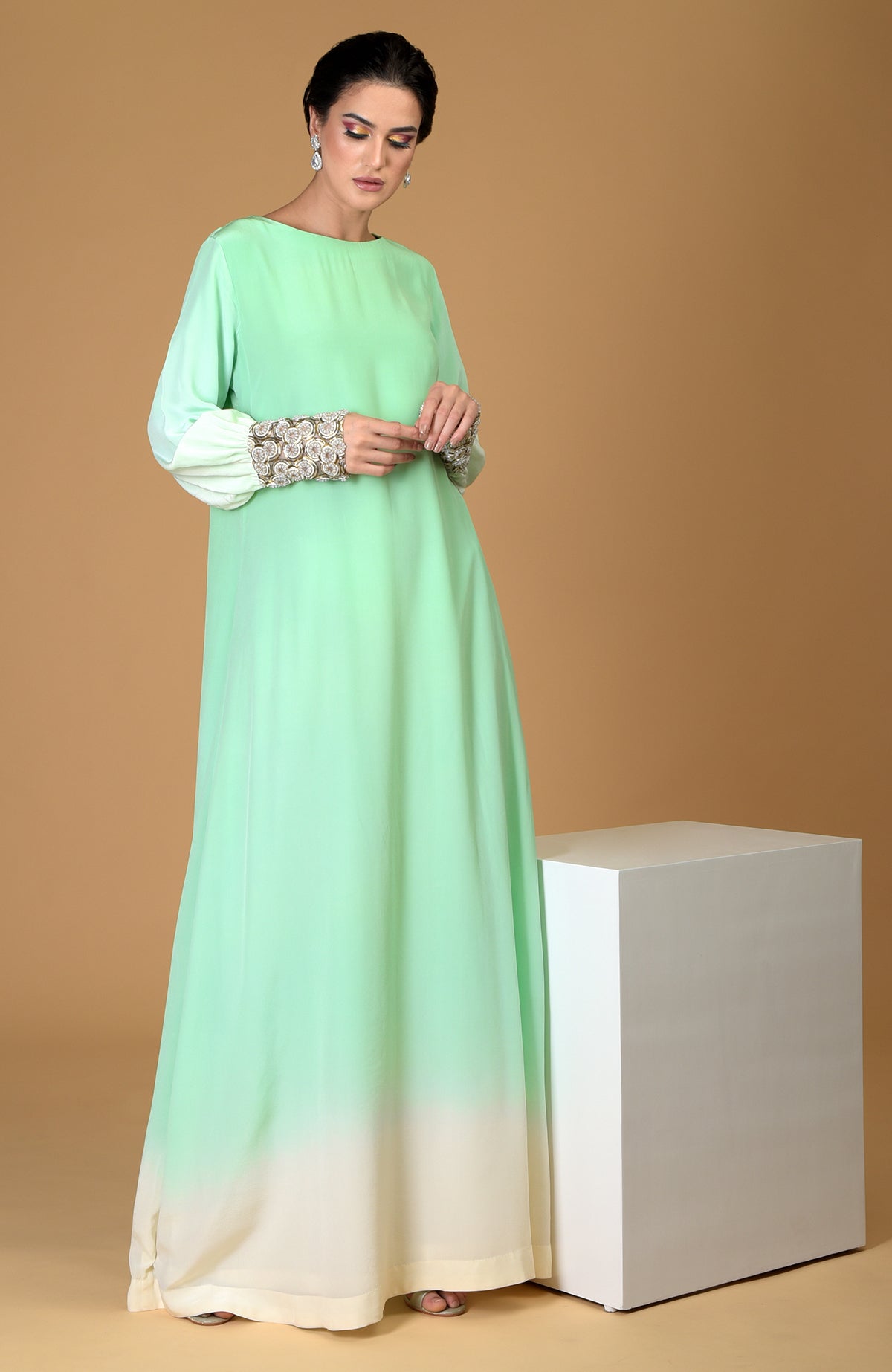 Ombre sage green silk crepe gown with sparkling circular jeweled cuffs.