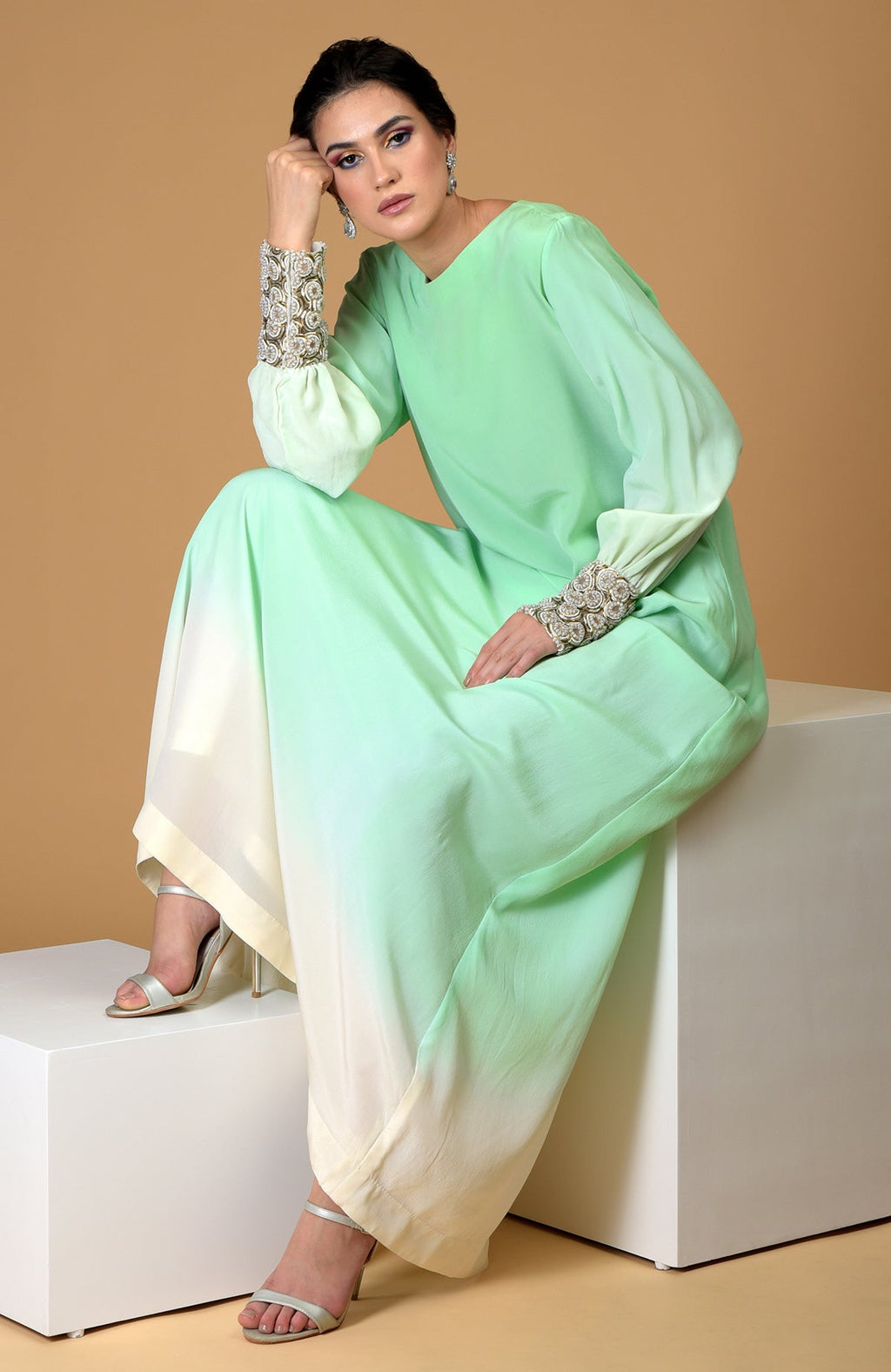 Ombre sage green silk crepe gown with sparkling circular jeweled cuffs.