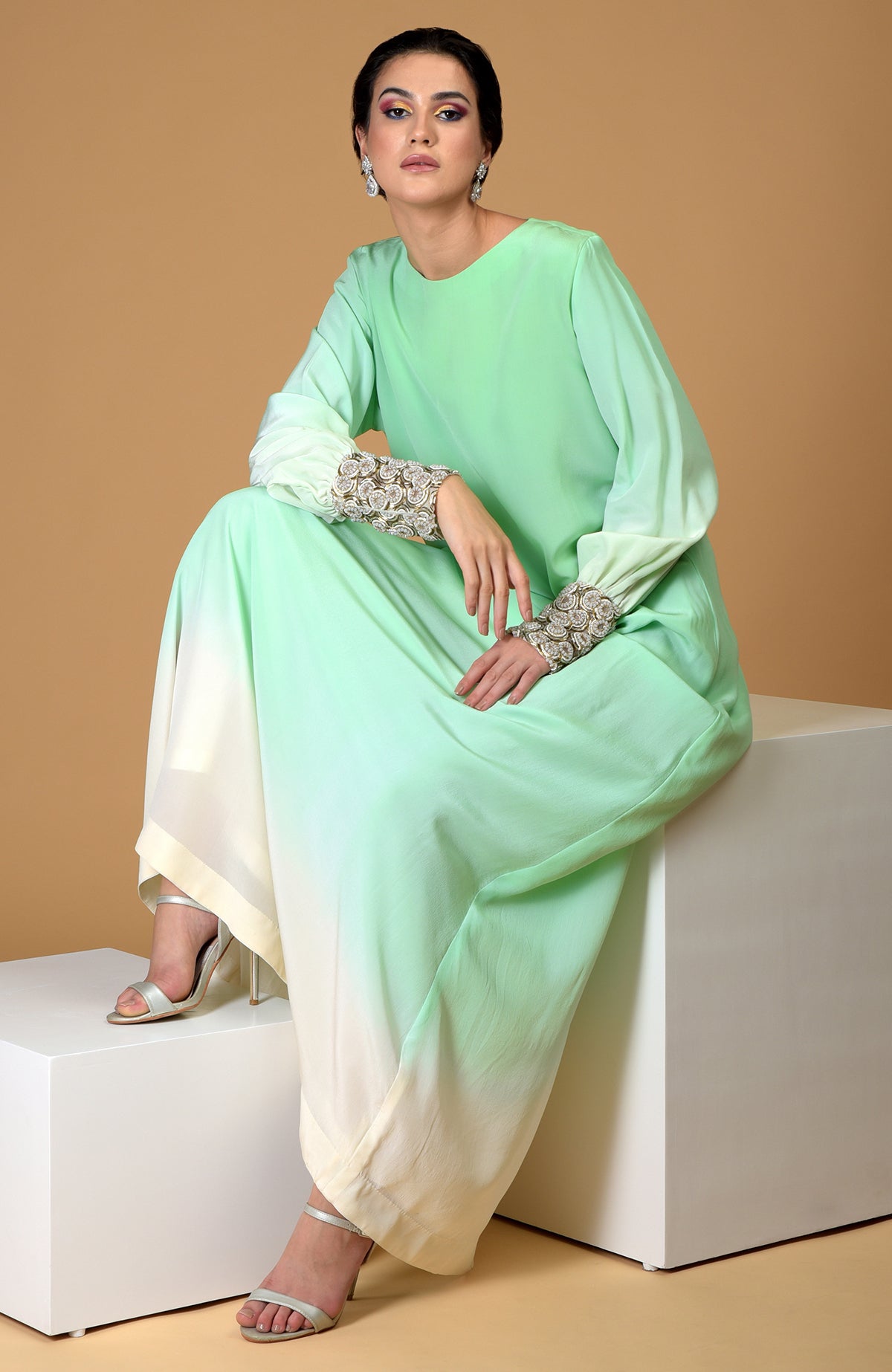 Ombre sage green silk crepe gown with sparkling circular jewelled cuffs.