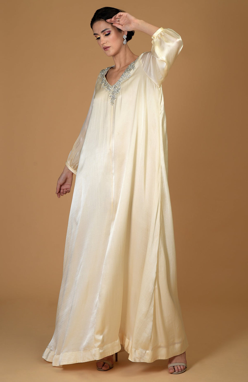 A woman models a white gold crystal cluster hand-embroidered dress.