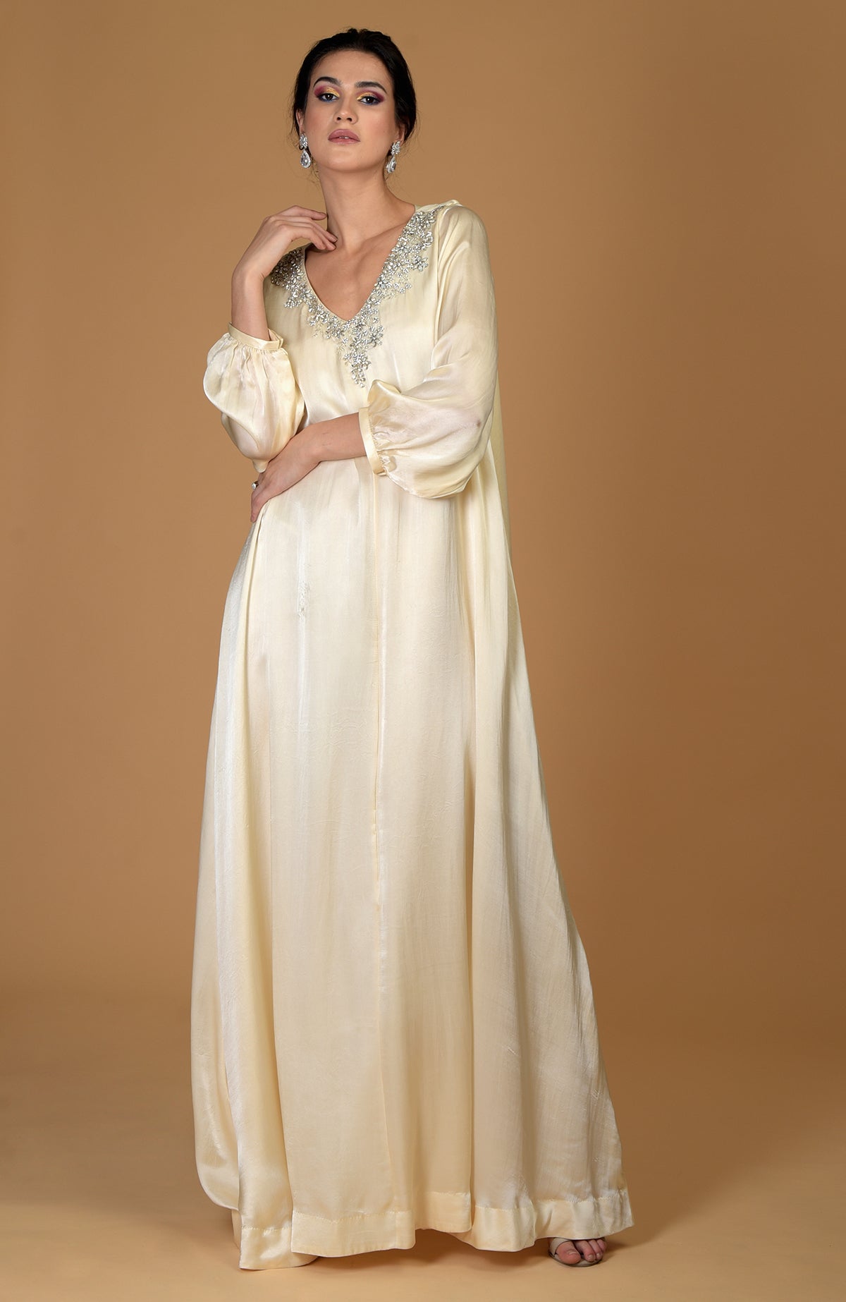 A woman models a white gold crystal cluster hand-embroidered dress.