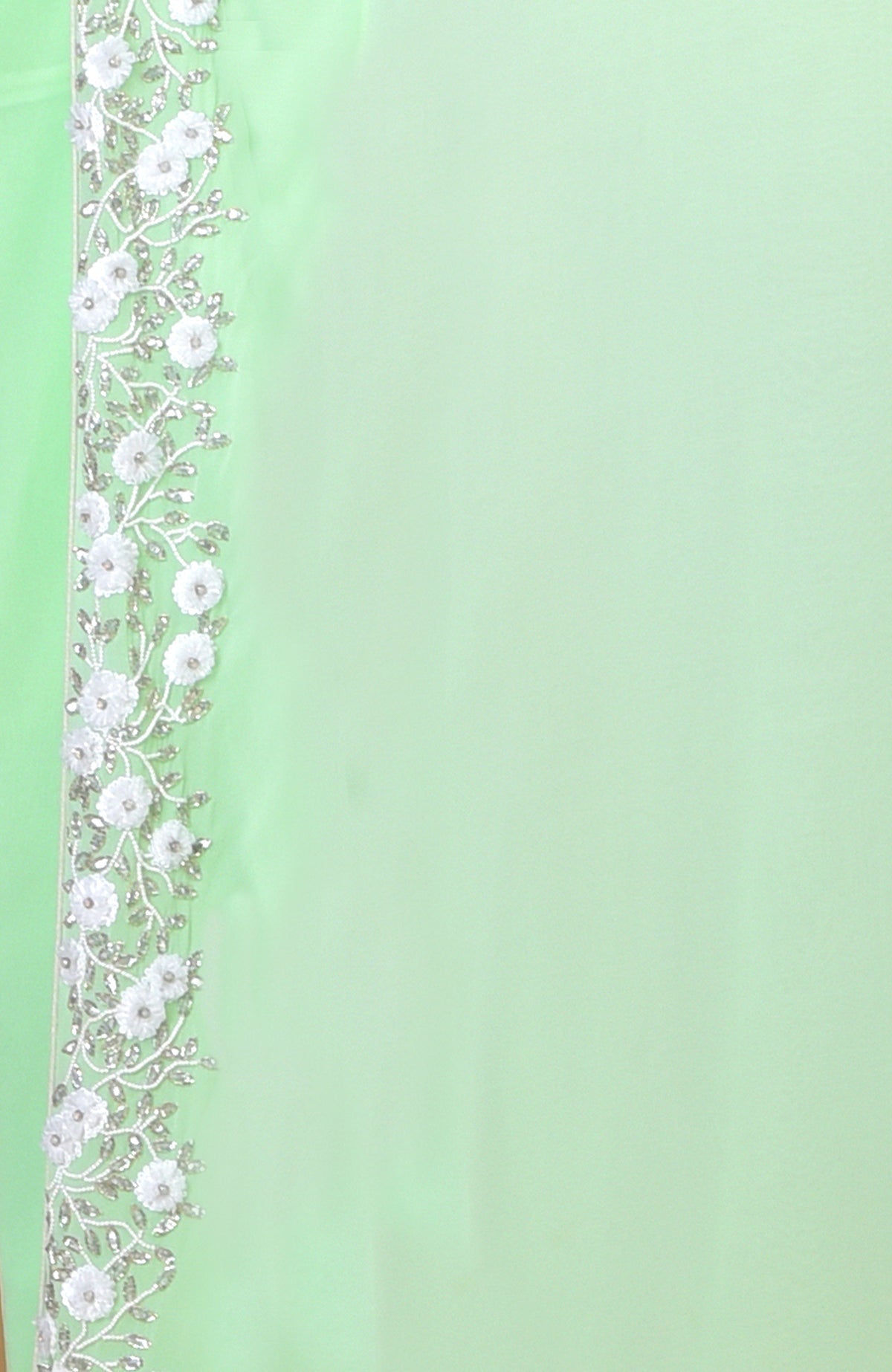 Mint green dress with white floral and silver vine embroidery along the left edge.