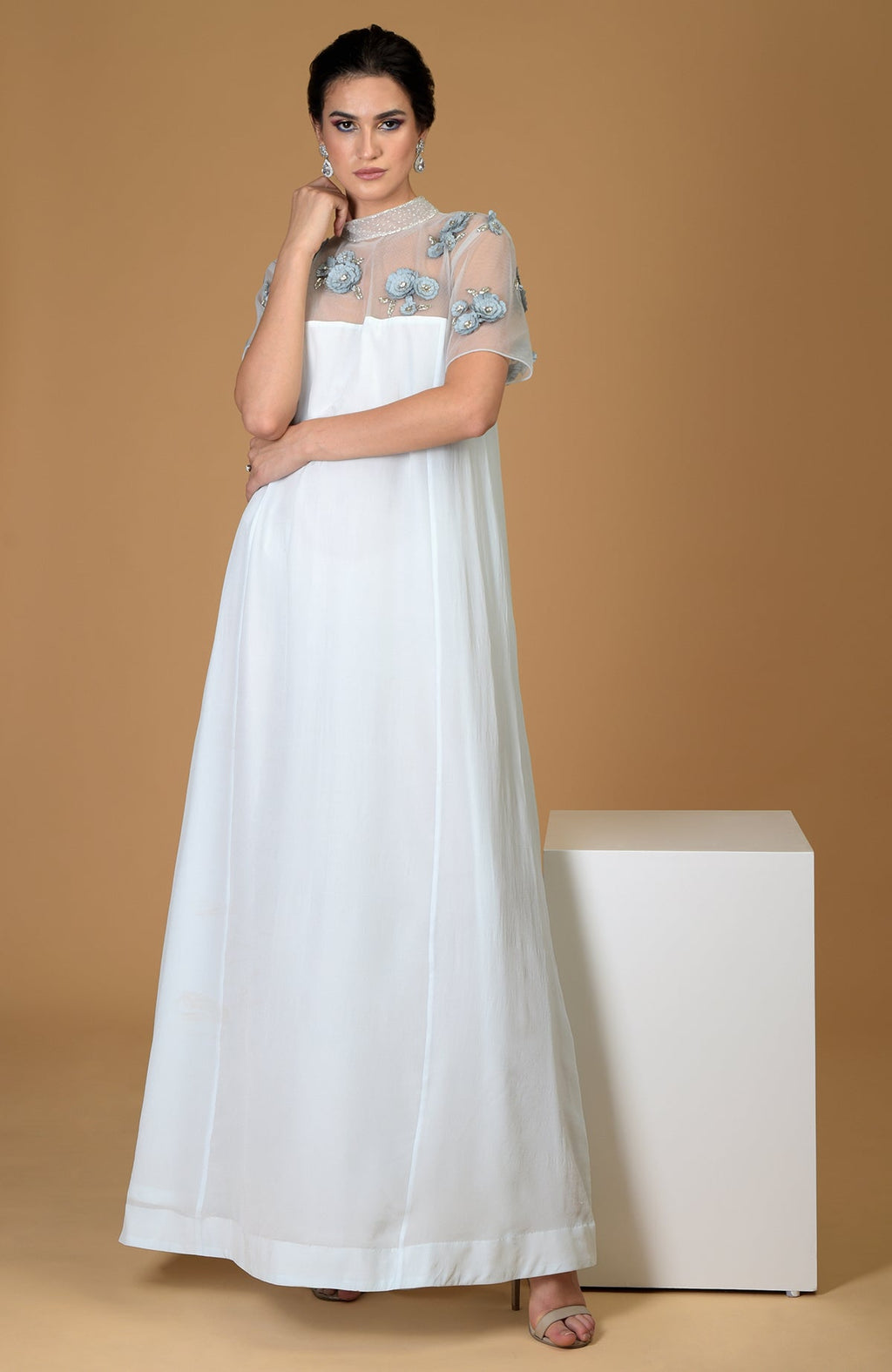 A woman models a blue twilight hand-embroidered dress with floral details.