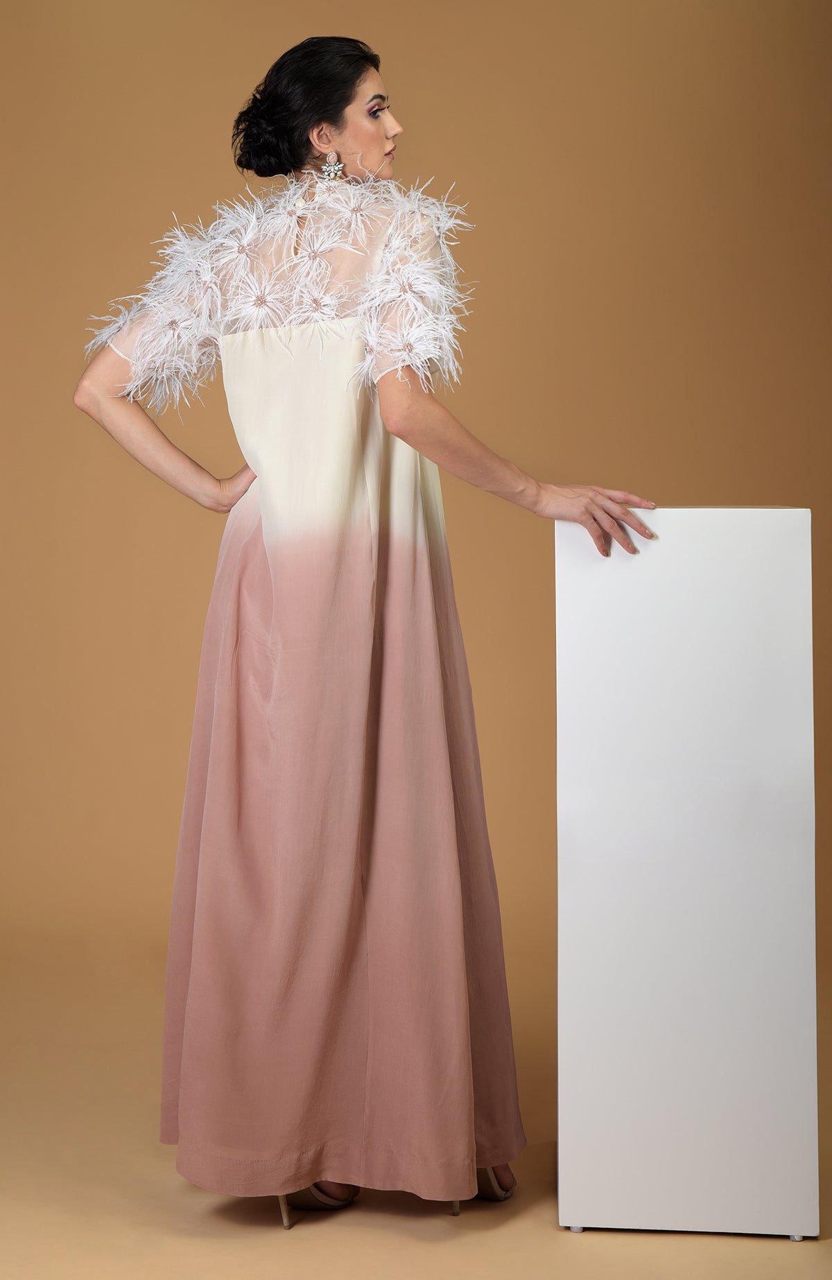 A woman models an ombre silk crepe dress with feather floral embroidery.