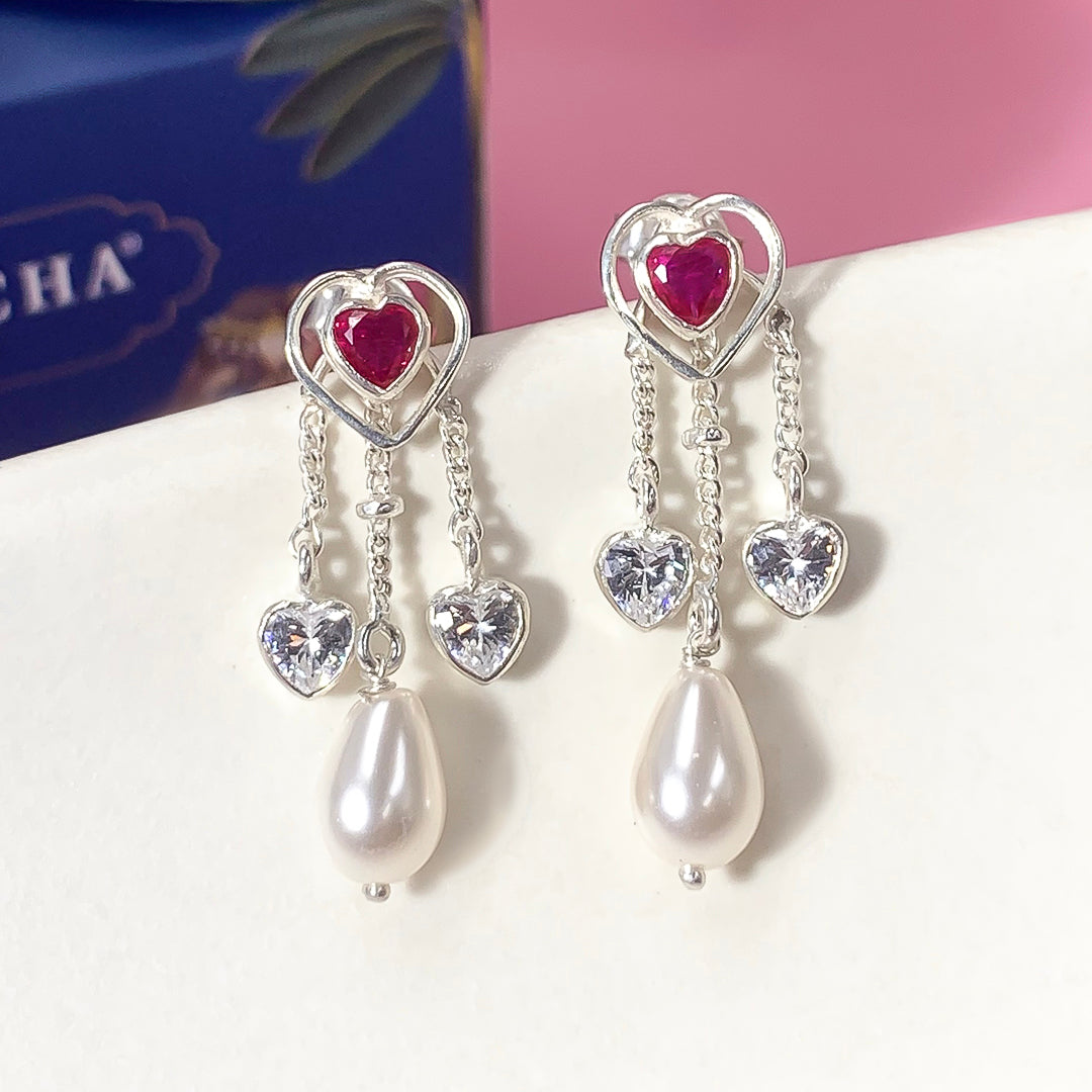 Handcrafted silver necklace with matching earrings by Unniyarcha, displayed on fabric with fine ethnic detailing