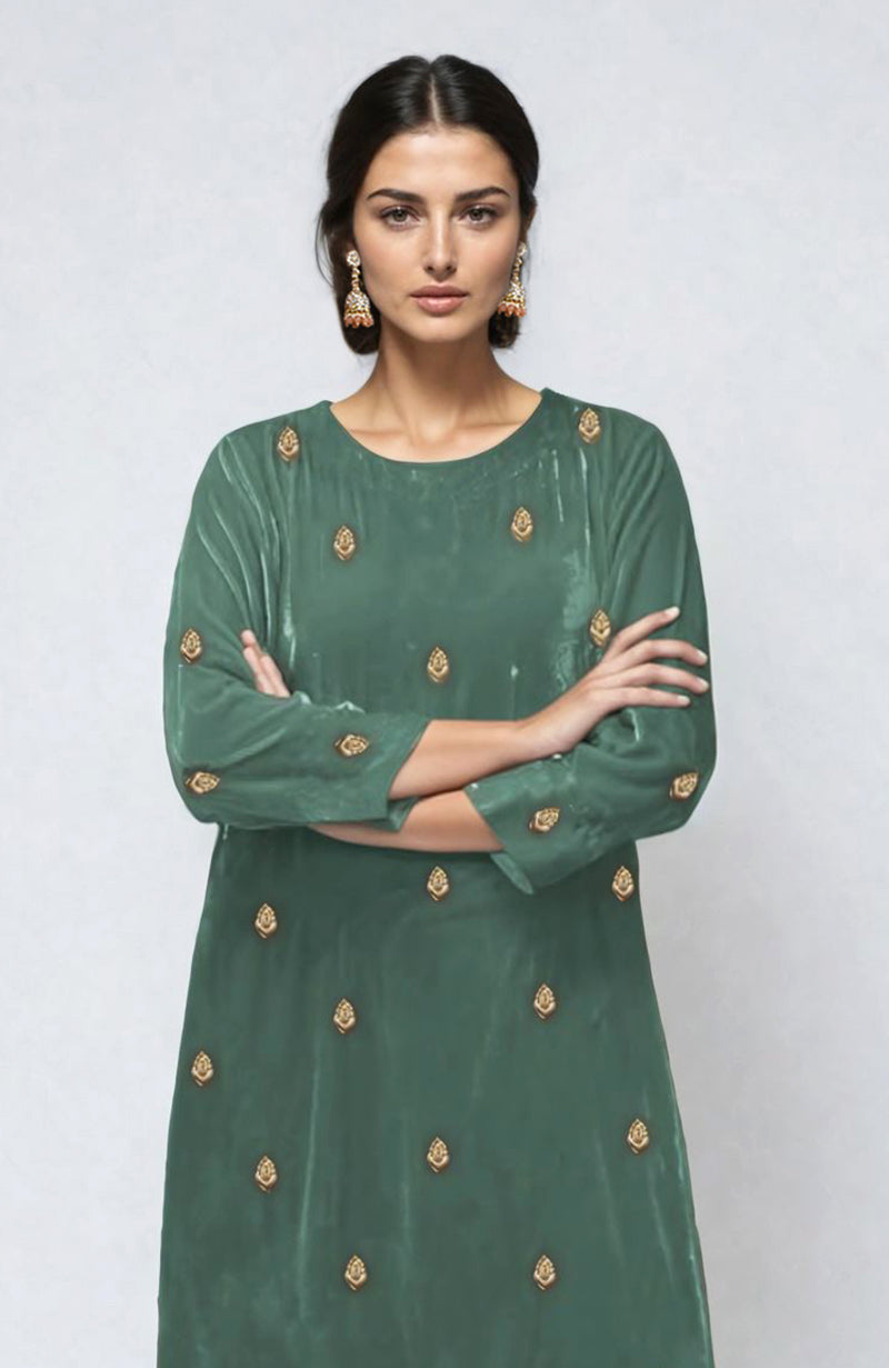 A woman models a jade green velvet kurta with gold dabka zardozi embroidery.
