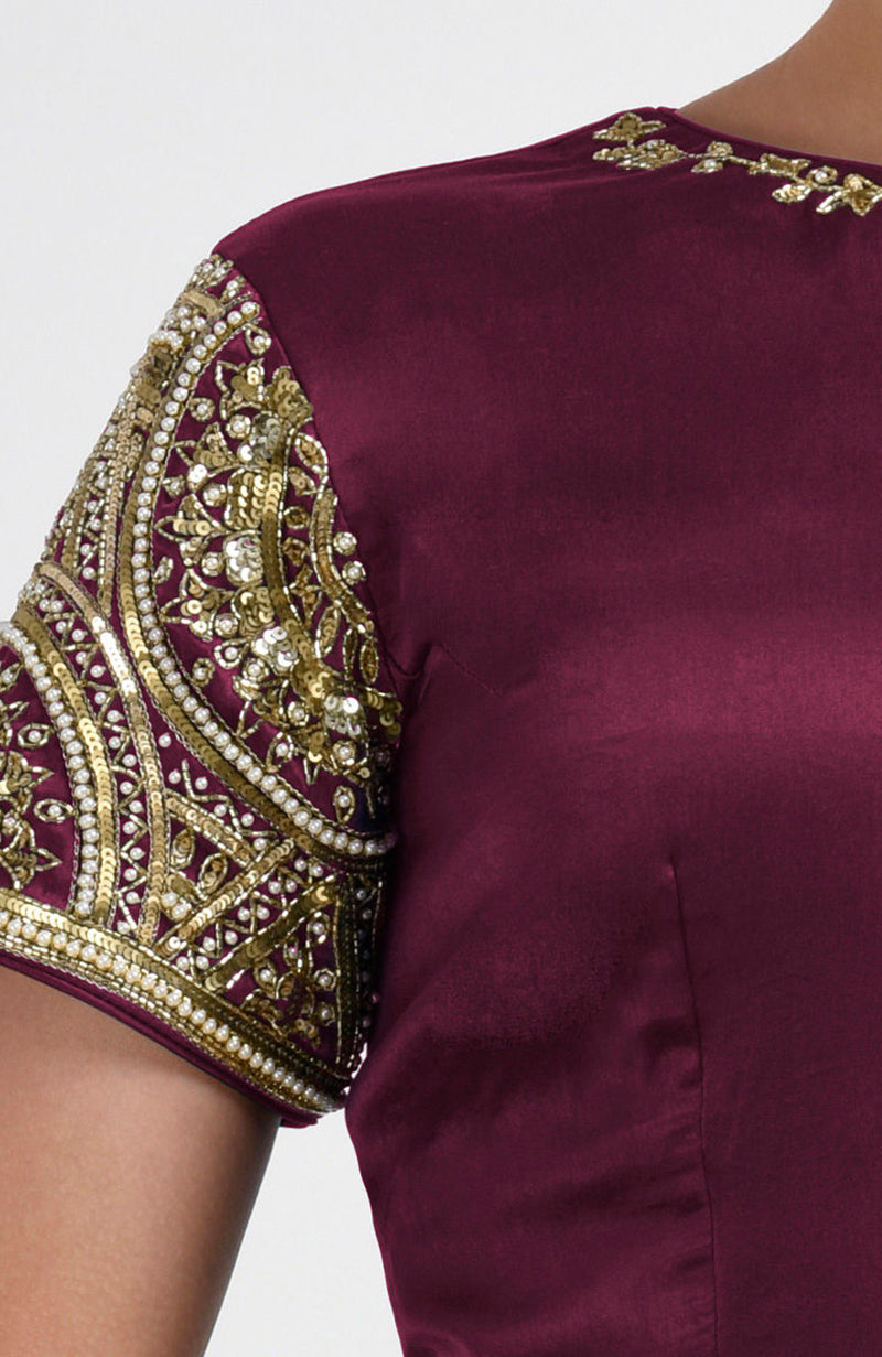 Burgundy satin silk blouse with intricate gold zardozi and pearl embroidery on the sleeves.