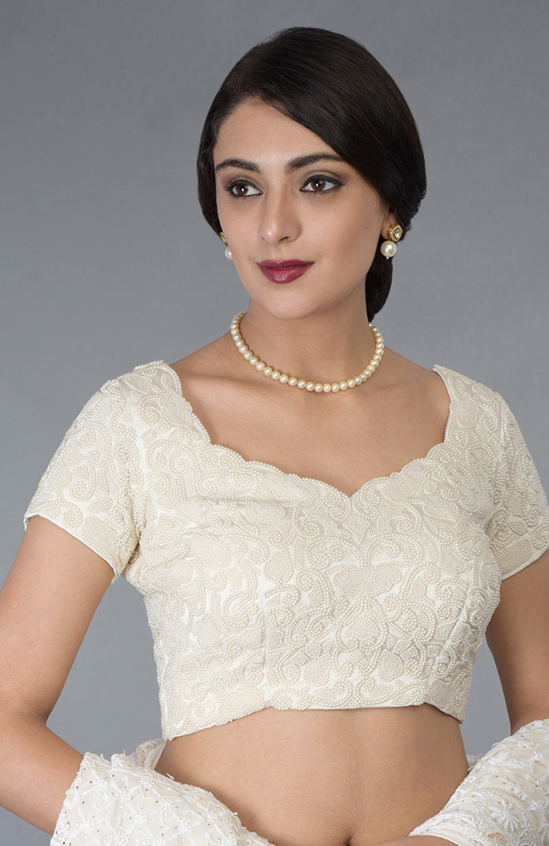 An ivory pearl beaded hand-embroidered blouse with a sweetheart neckline.
