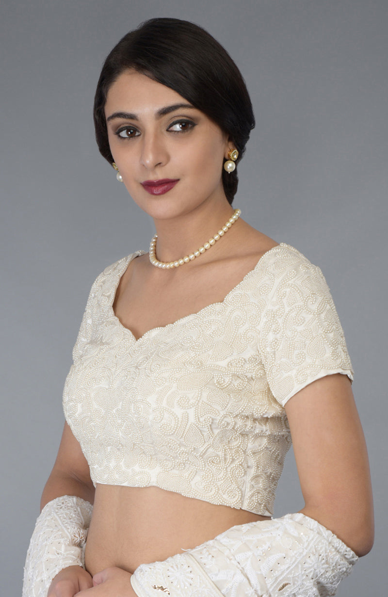 Ivory pearl beaded hand embroidered blouse with a sweetheart neckline and cap sleeves.