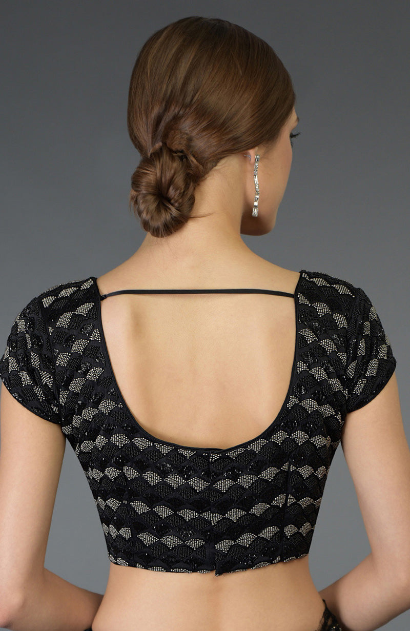 Woman from behind wearing a black zardozi and beads hand embroidered blouse.