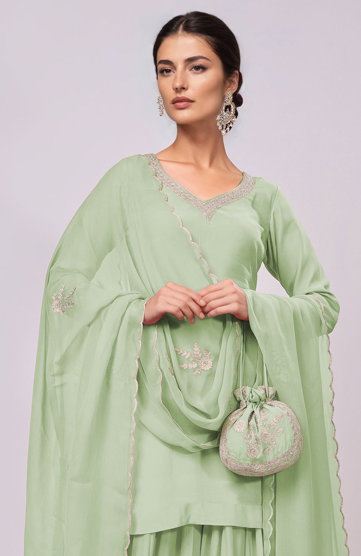 Sage green sharara set with Kashmiri Tilla Aari embroidery and matching potli bag.