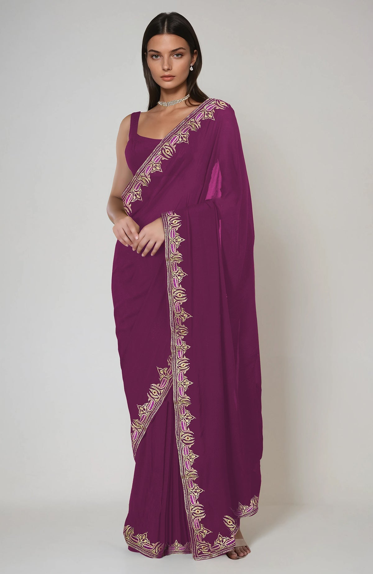 A woman models a peacock pink saree with intricate gold and pink embroidery.