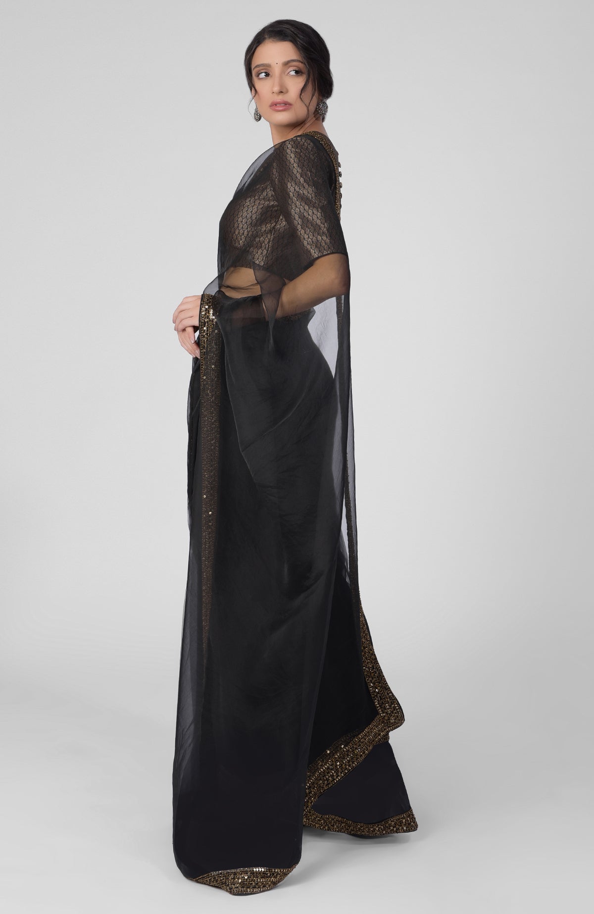 Black silk organza saree with gold hand embroidered zardozi border and brocade blouse.