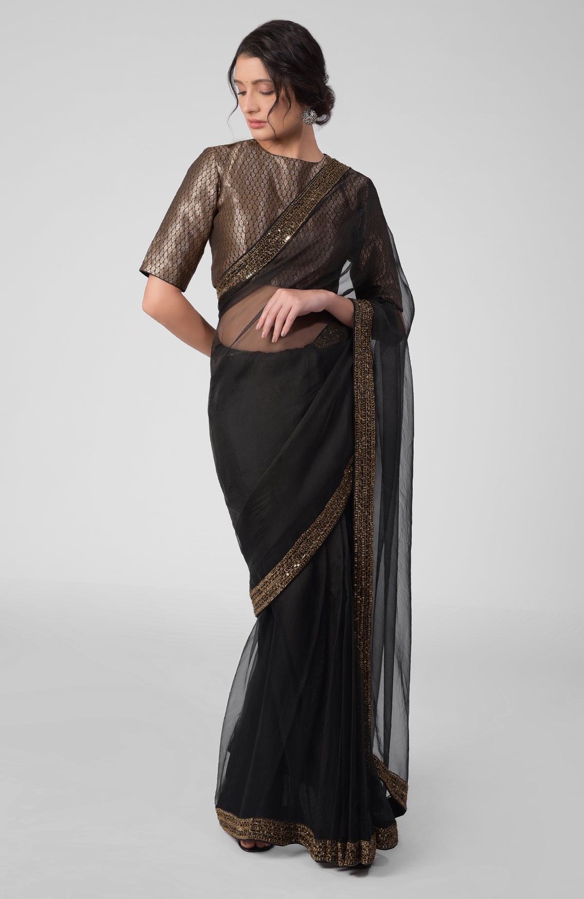 Black silk organza saree with gold hand embroidered zardozi border and brocade blouse.