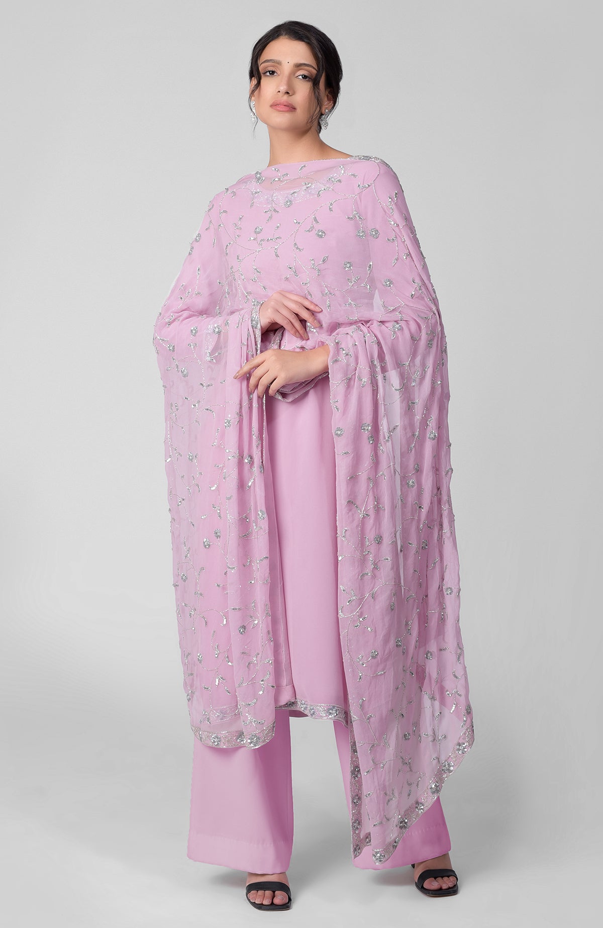 A woman models a delicate blue kurta set with silver beads and sequin zardozi embroidery.