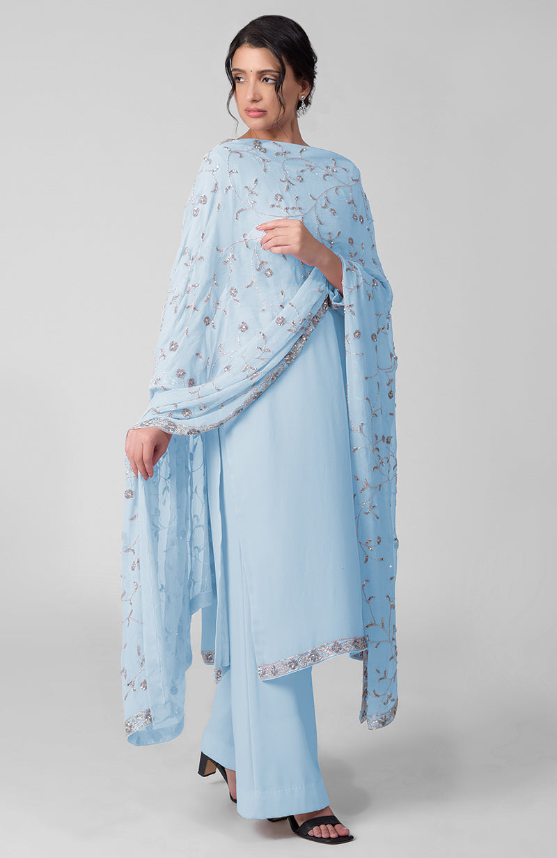 A woman models a delicate blue kurta set with silver beads and sequin zardozi embroidery.