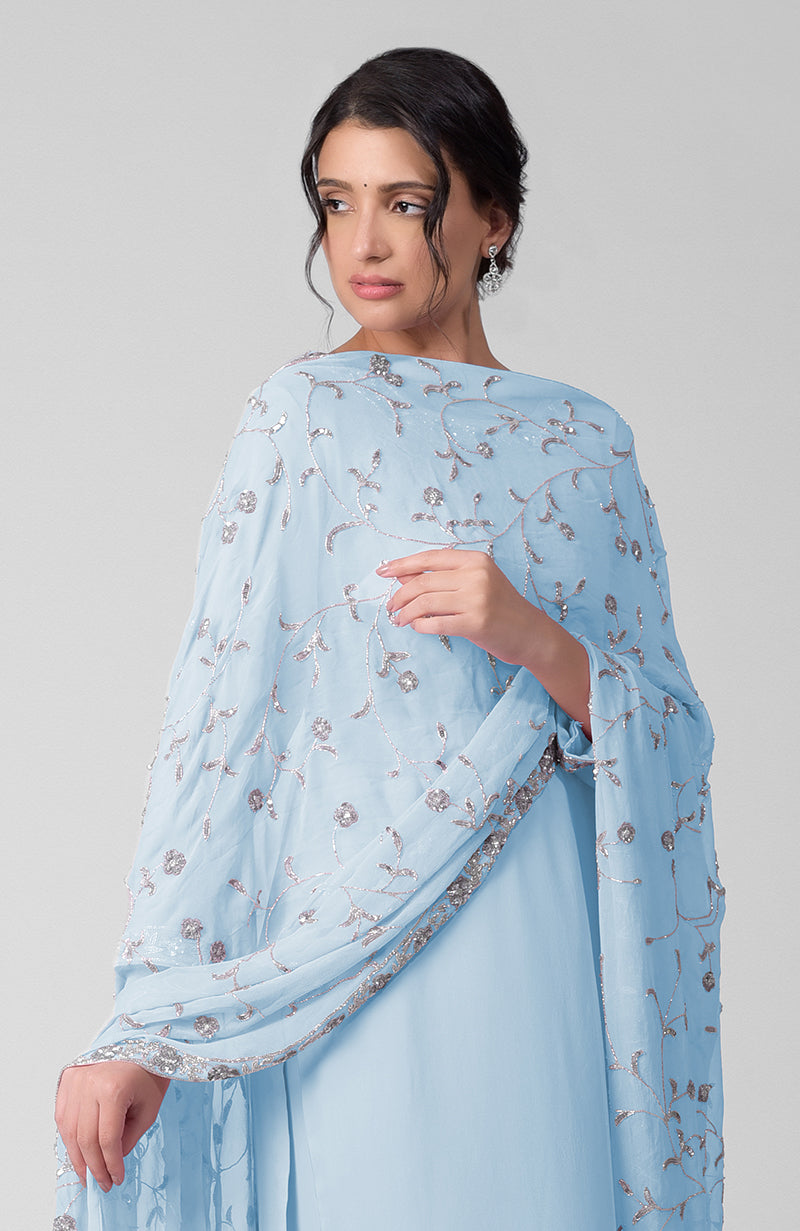 A woman models a delicate blue kurta set with silver bead and sequin embroidery.