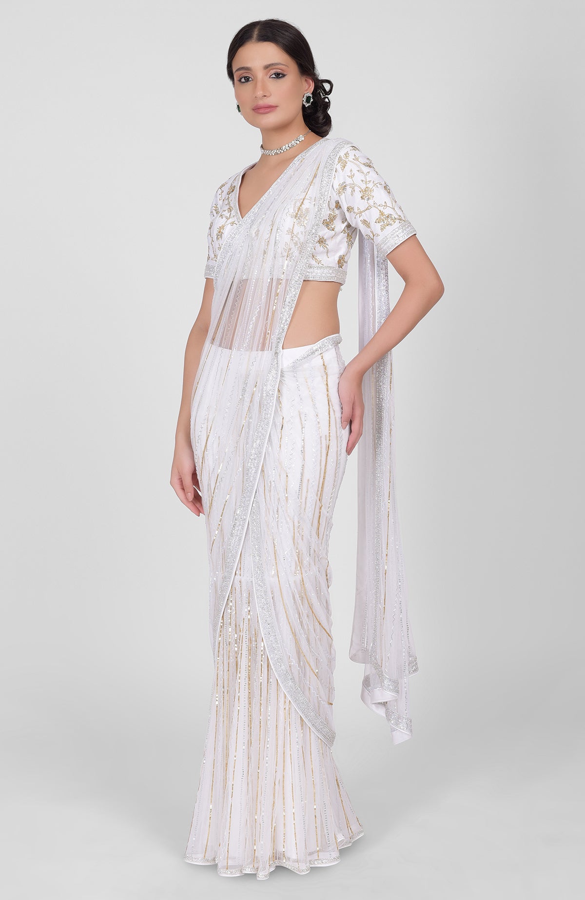 White tulle saree with gold, silver sequins and beads, paired with gold embroidered blouse.
