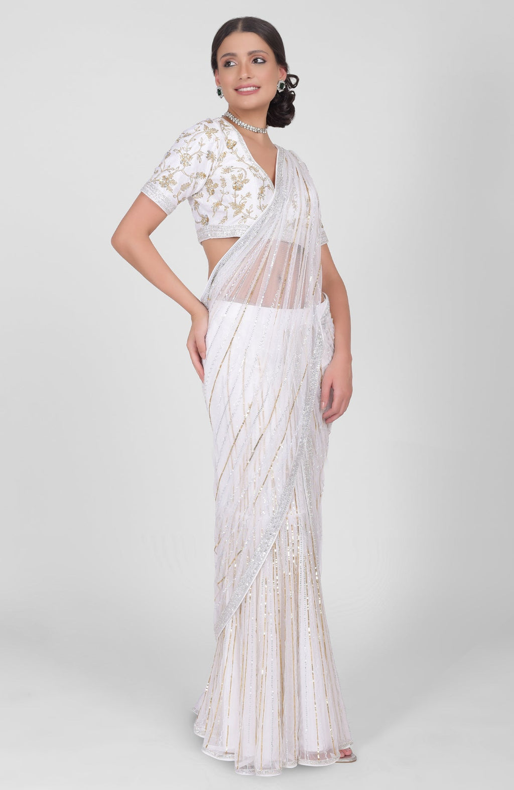 White tulle saree with gold, silver sequins and beads paired with gold embroidered blouse.