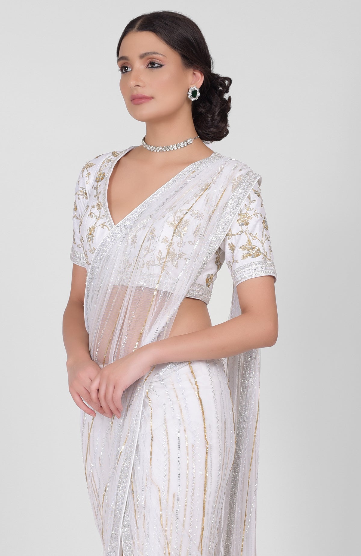 White tulle saree with gold, silver sequins and beads, paired with gold embroidered blouse.