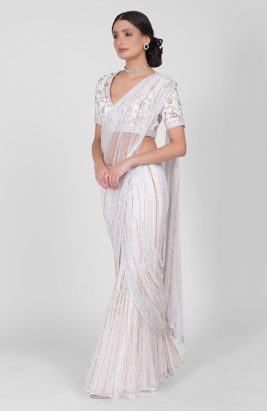 White saree with gold, silver sequins and beads hand embroidery and gold zari blouse.