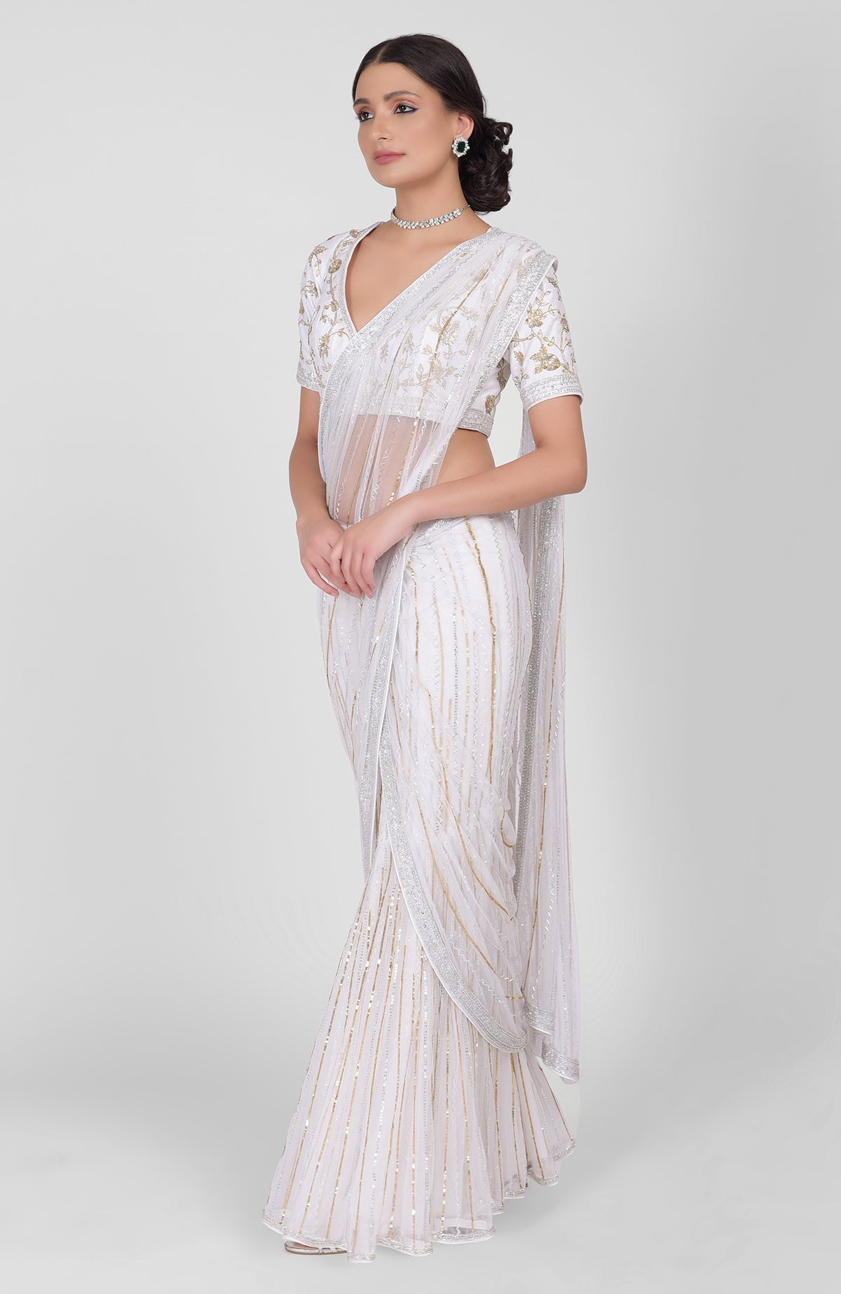 White saree with gold, silver sequins and beads hand embroidery and gold zari blouse.