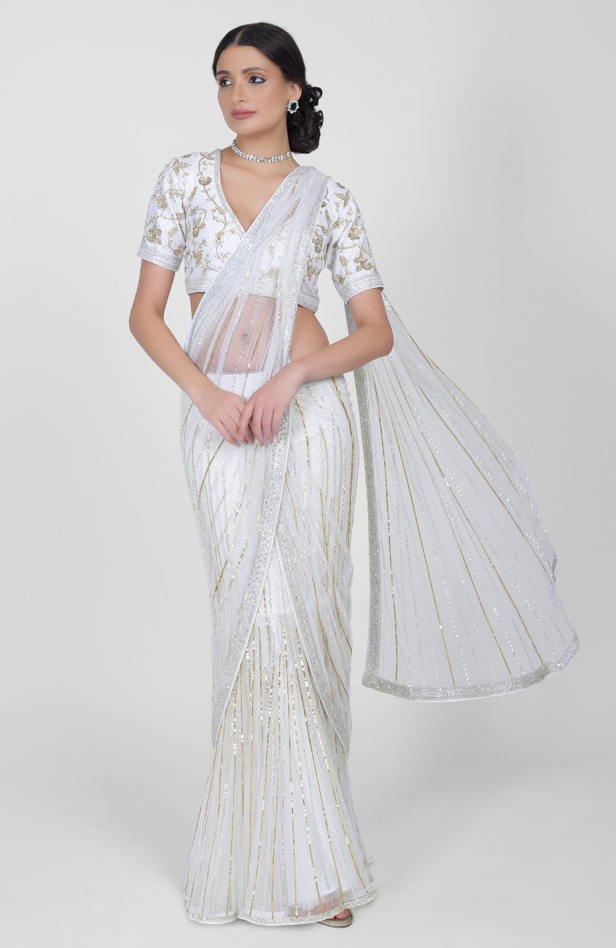 White tulle saree with gold, silver sequins and beads paired with gold embroidered blouse.