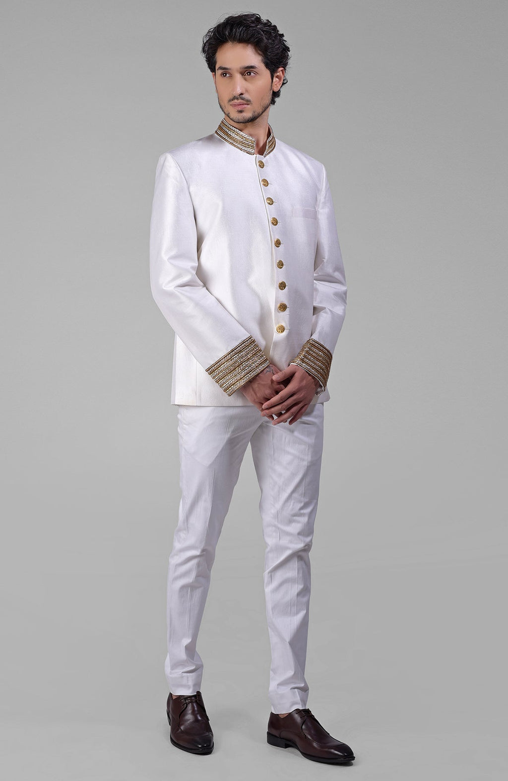 Ivory silk bandhgala jacket with gold zardozi embroidery and golden button closure paired with white pants