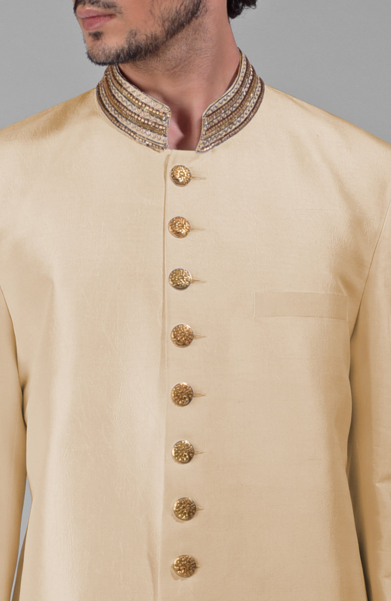 Gold silk bandhgala jacket with zardozi embroidery, beadwork, sequins, and golden buttons paired with white pants