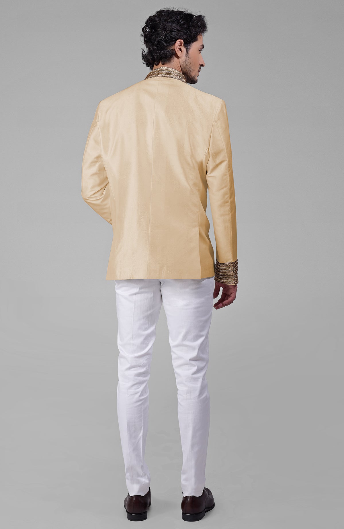 Gold silk bandhgala jacket with zardozi embroidery, beadwork, sequins, and golden buttons paired with white pants