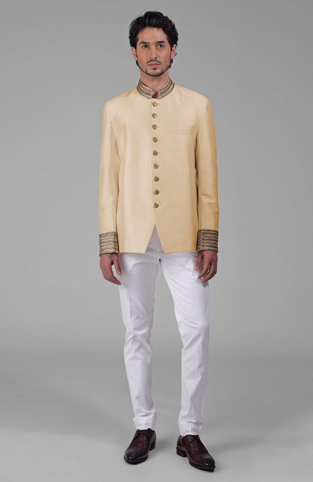 Gold silk bandhgala jacket with zardozi embroidery, beadwork, sequins, and golden buttons paired with white pants