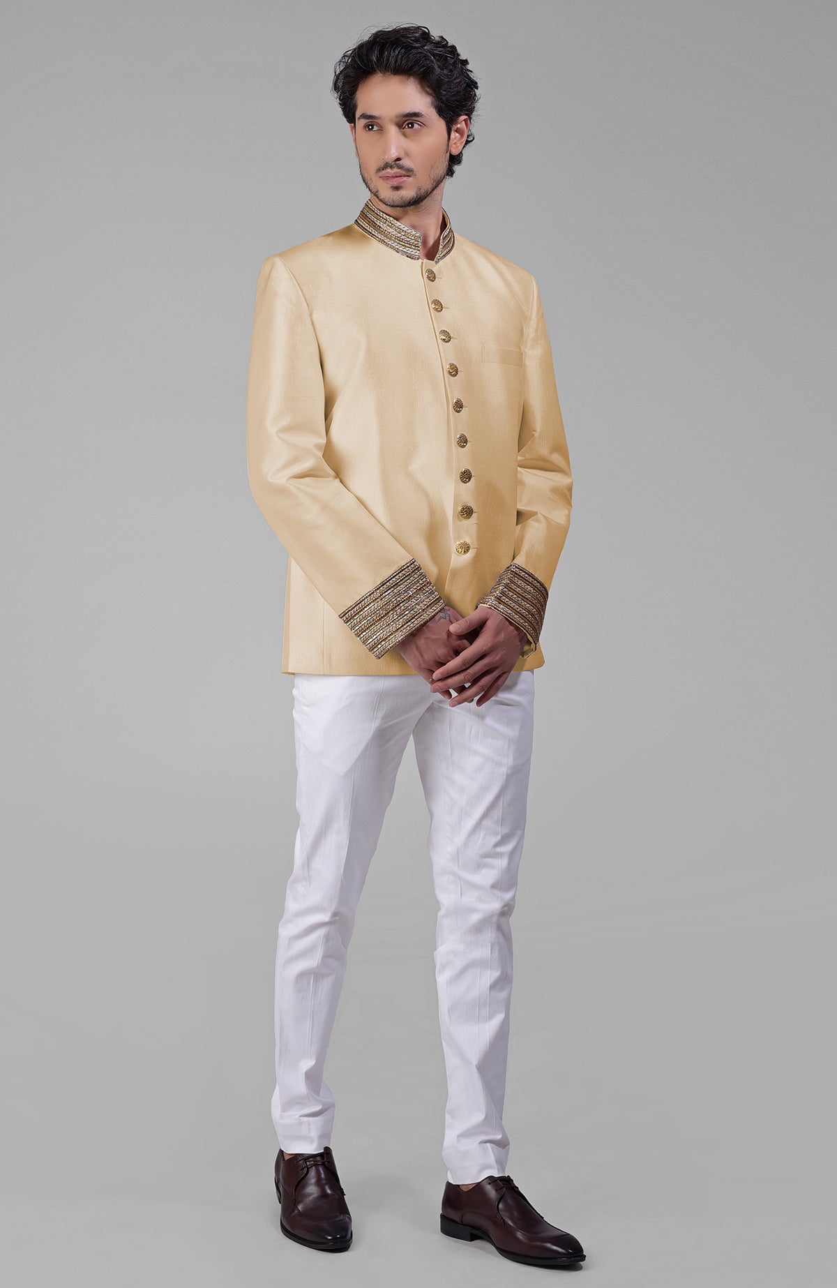 Gold silk bandhgala jacket with zardozi embroidery, sequins, beads, and golden buttons paired with white pants.