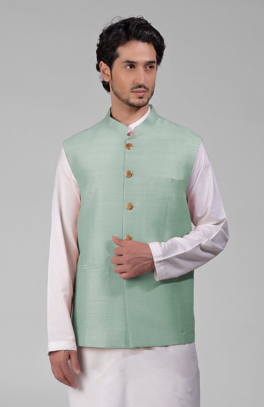 Gossamer green pure raw silk waistcoat bandi jacket with gold peacock button closure.
