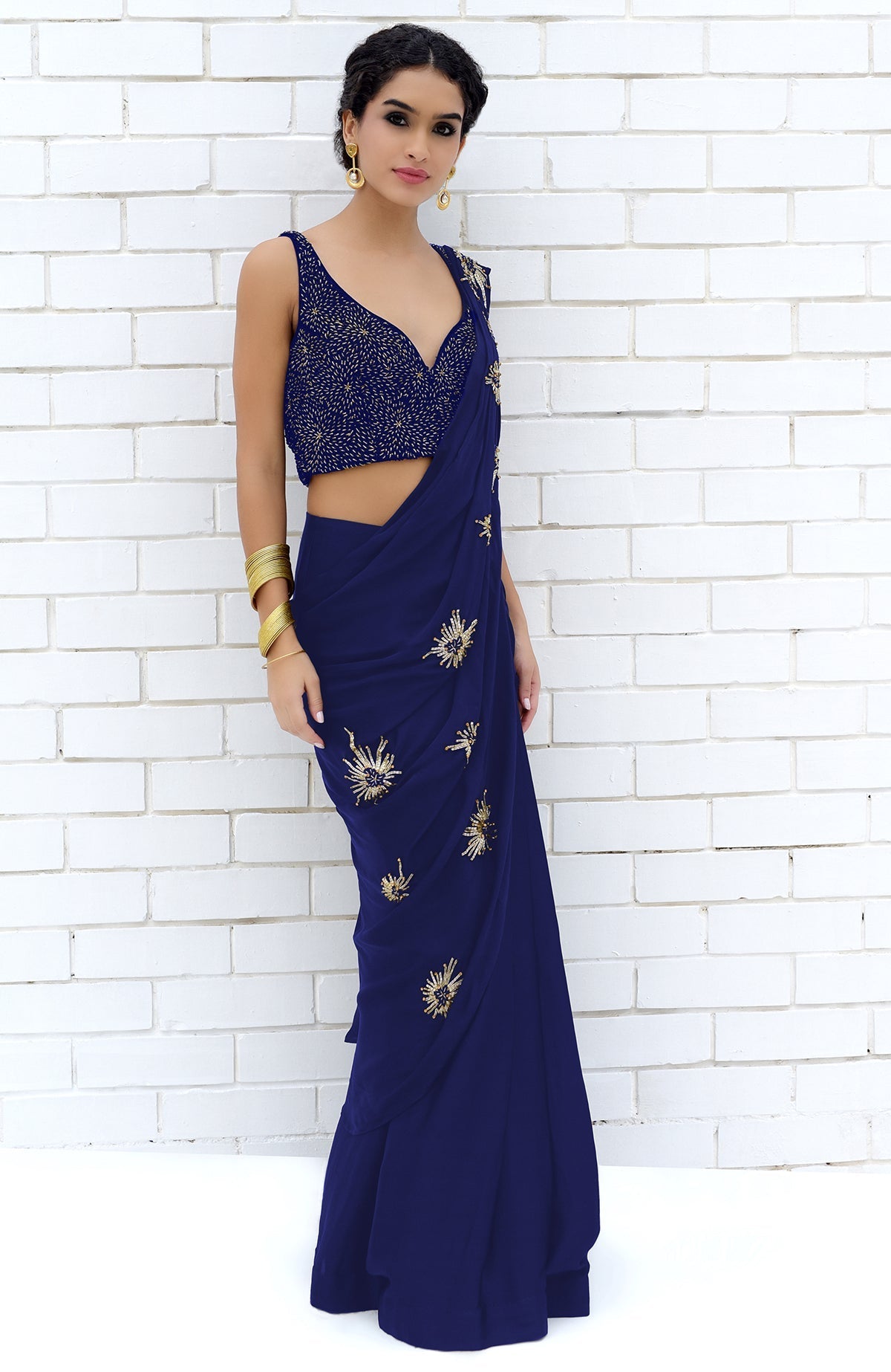 A woman models a royal blue saree with a matching embroidered blouse.