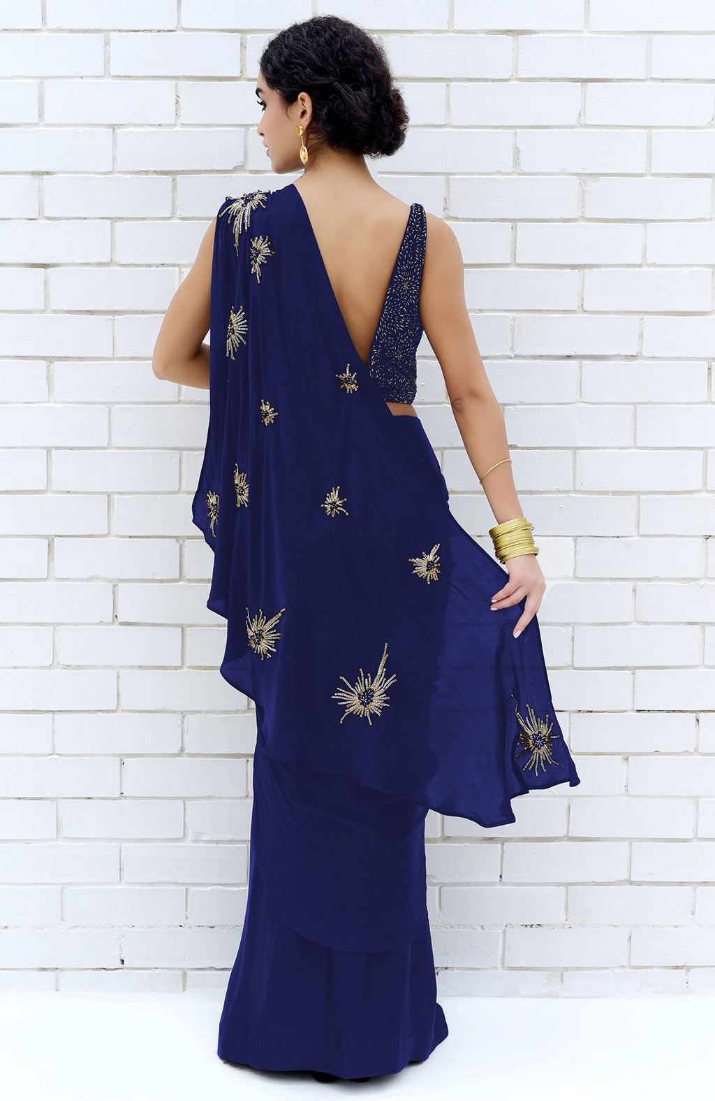 Royal blue saree with gold starburst embroidery and a matching blouse.