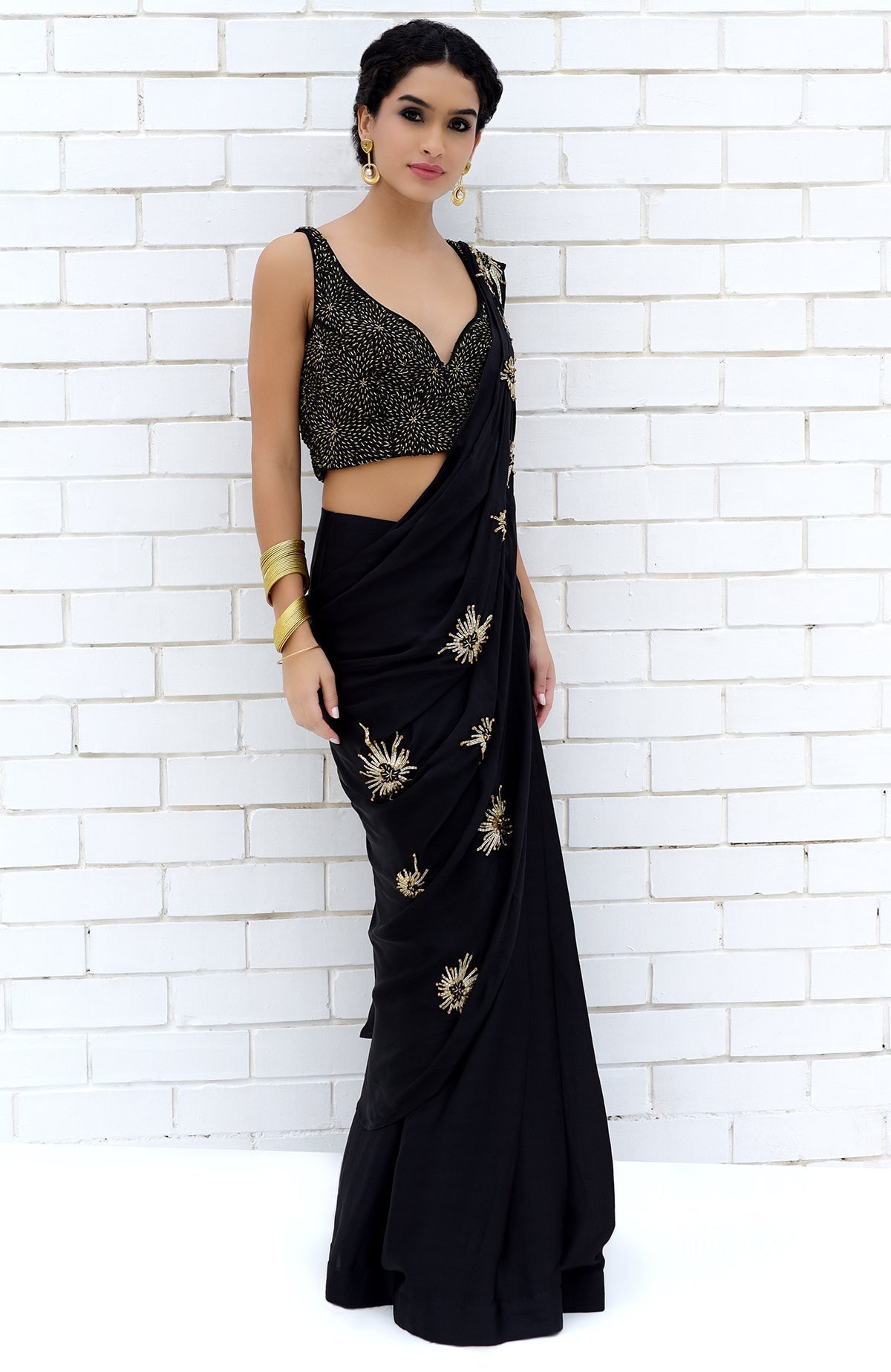Black pre-draped saree with a matching blouse featuring gold starburst embroidery.