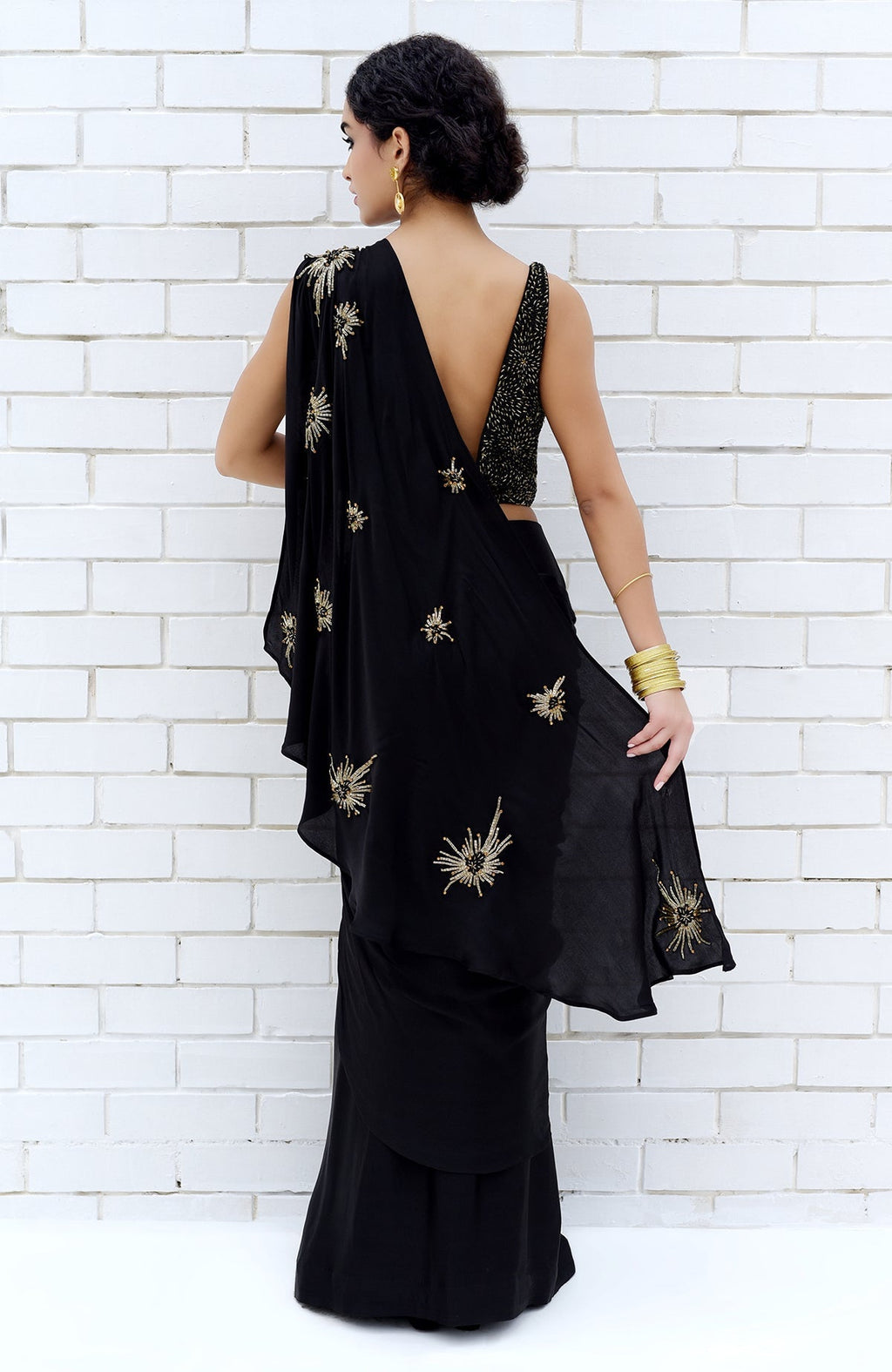 Black hand-embroidered saree with starburst beads and sequin work, worn with a matching blouse.
