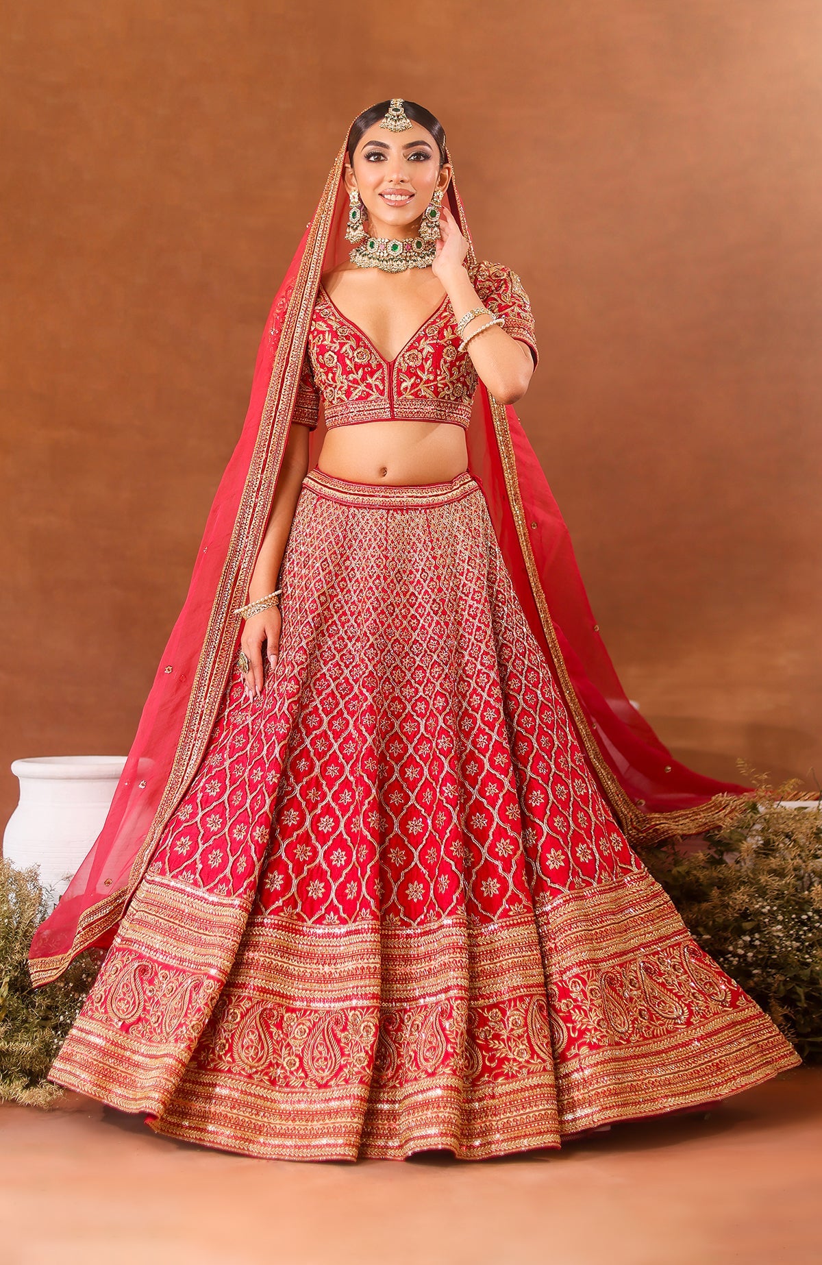 A three-piece purple wine lehenga set with intricate embroidery and a flowing organza dupatta.
