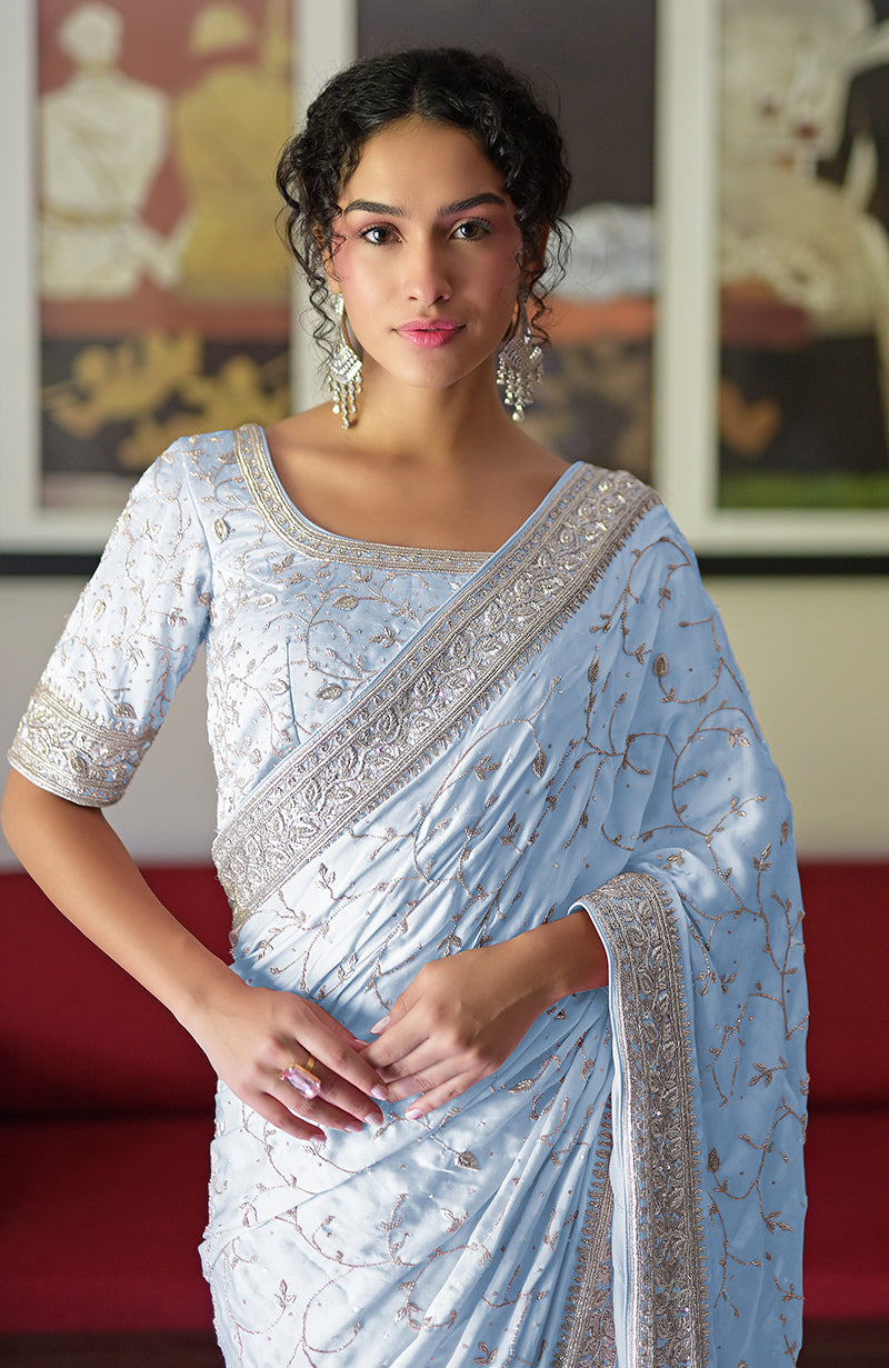 A woman models a light blue pure silk saree with silver zardozi embroidery.