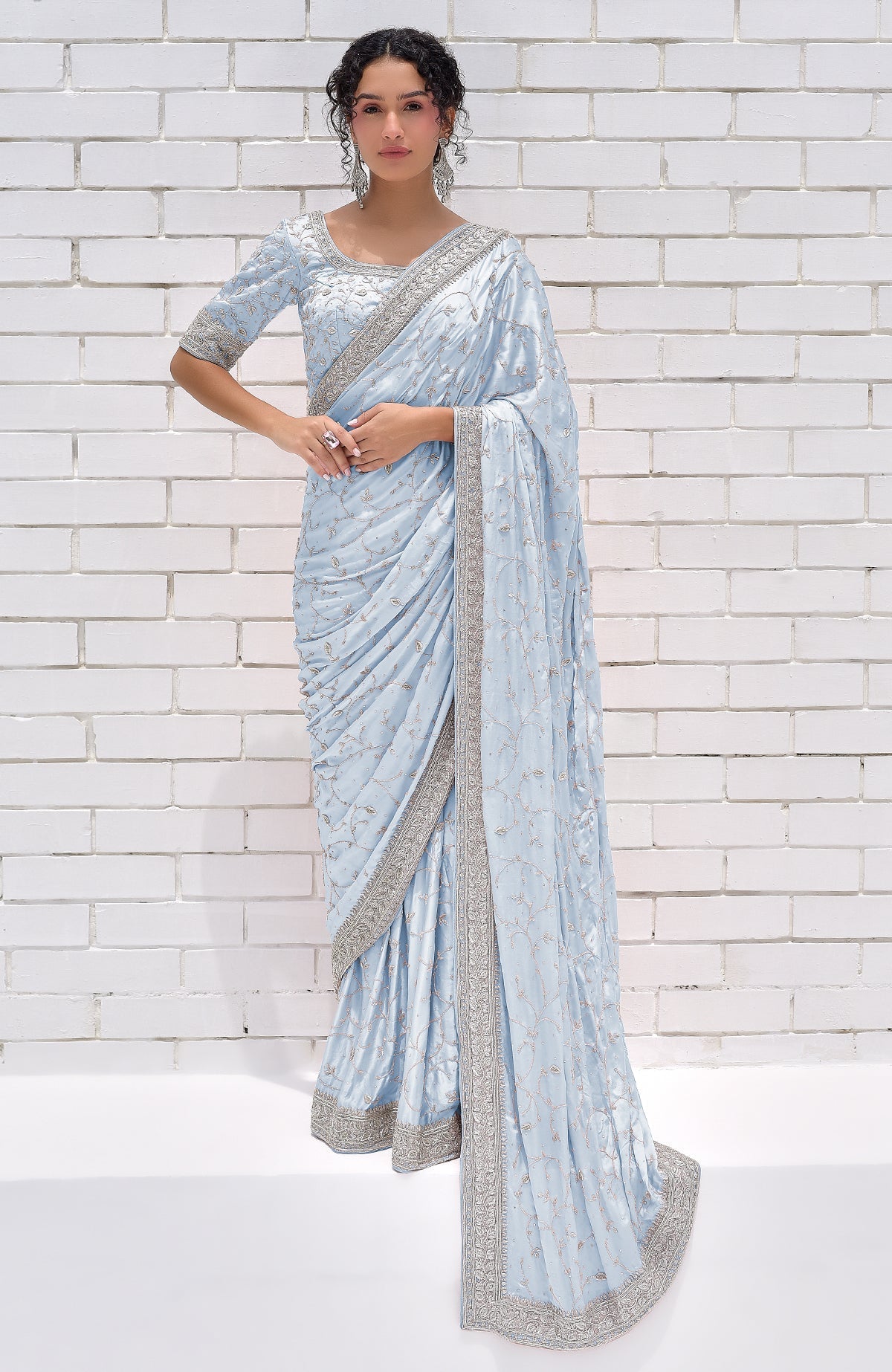 A woman models a powder blue pure silk saree with silver zardozi embroidery.