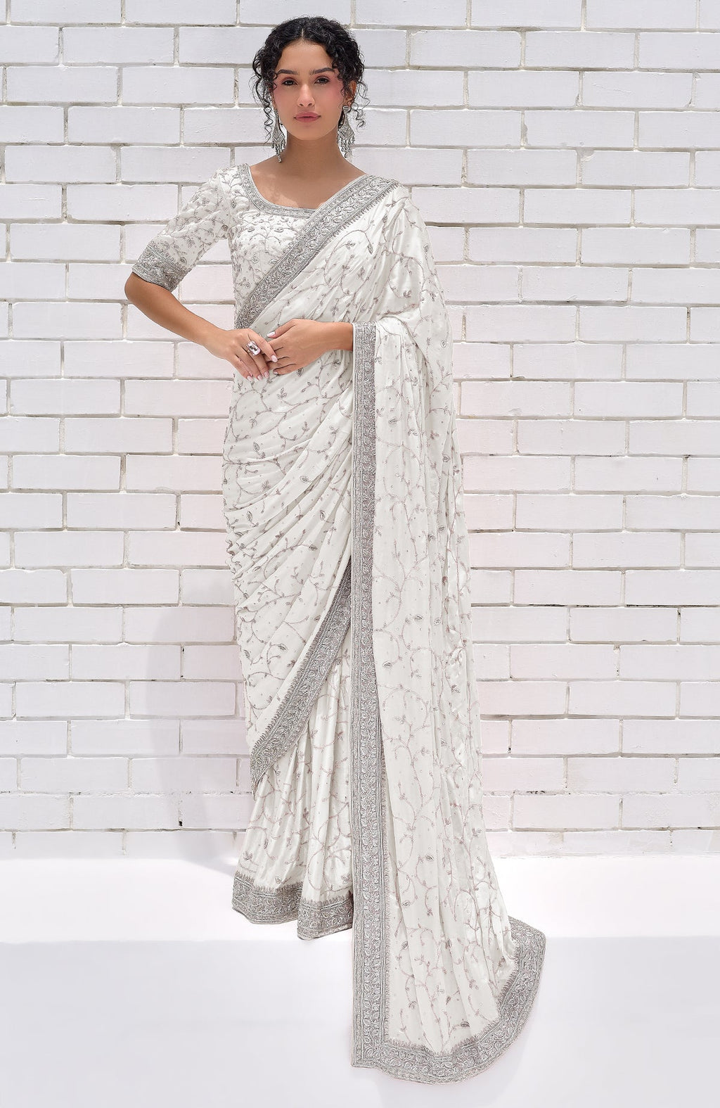 A woman models a pearl white pure silk saree with silver zardozi hand embroidery.