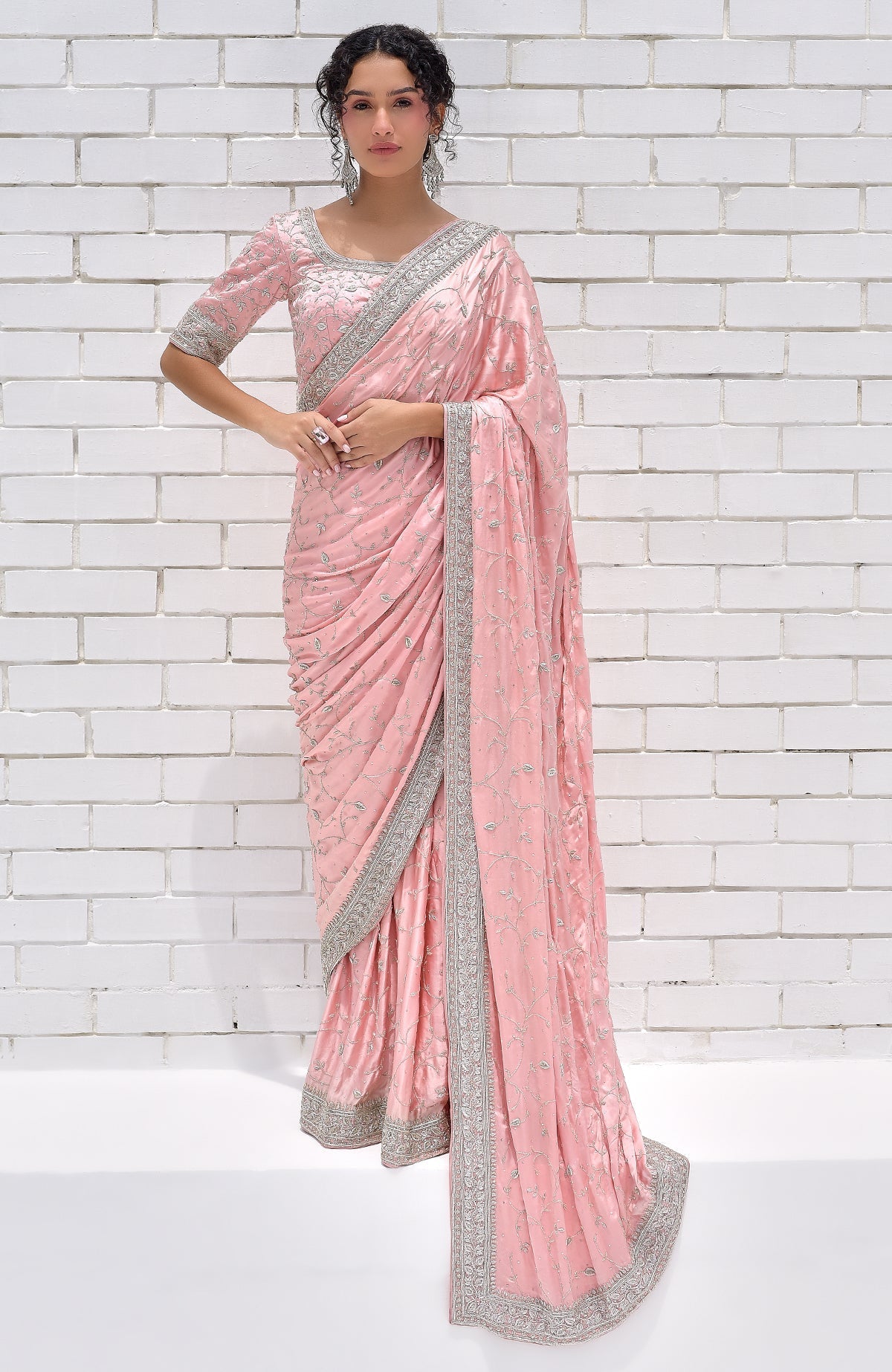 A woman models a pink pure silk saree with silver zardozi hand embroidery.