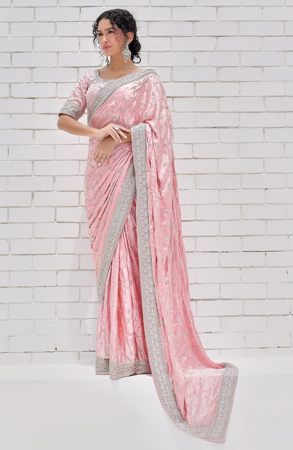 A woman models a pink pure silk saree with silver zardozi embroidery.