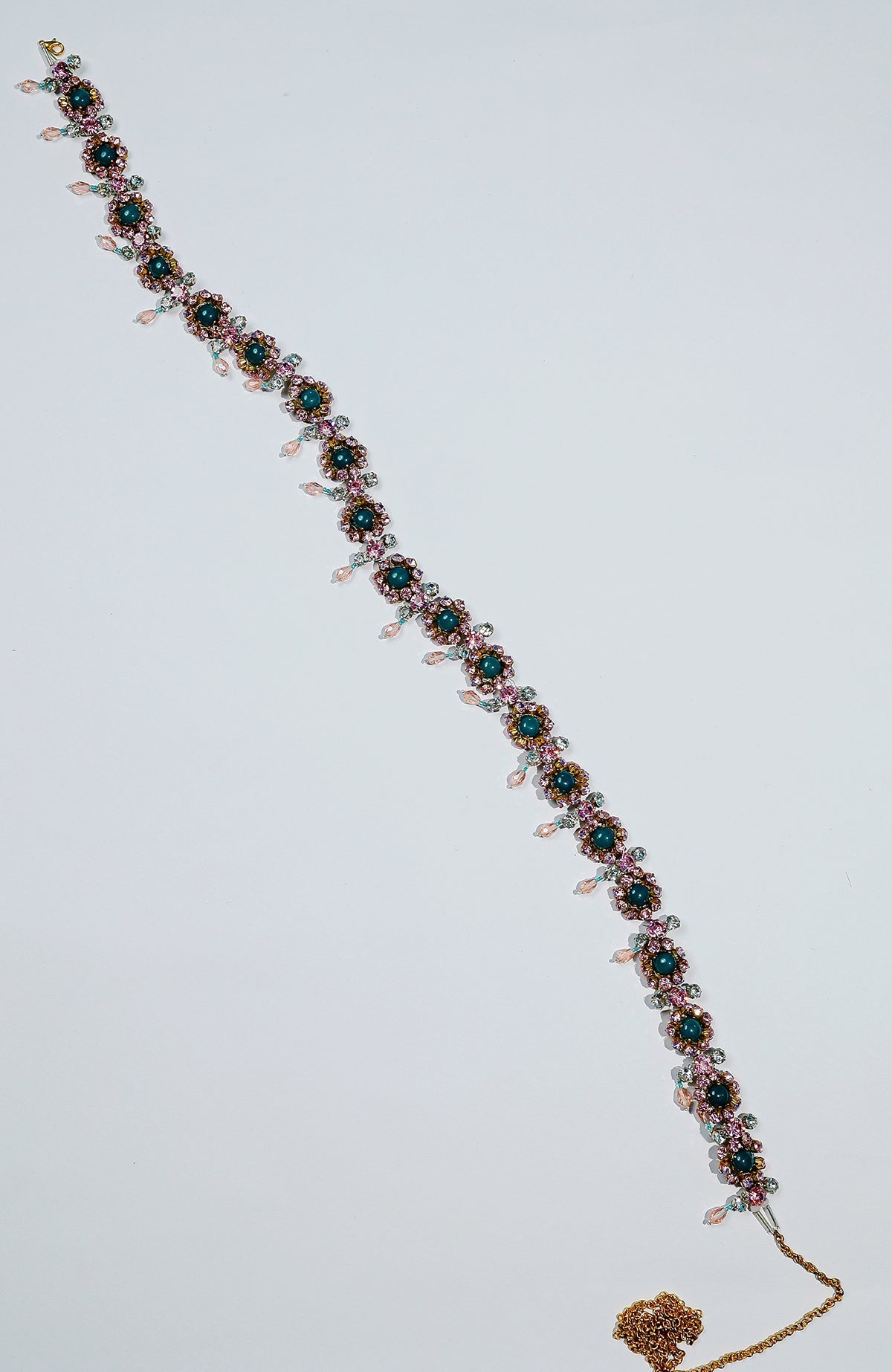 Pink belt adorned with green and pink crystals and gold dangling stones