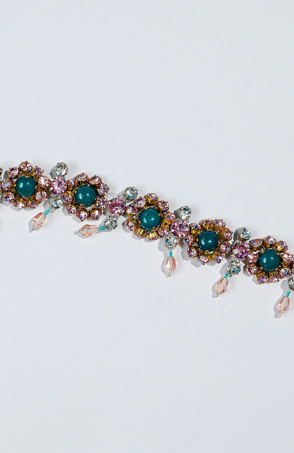 Pink belt adorned with green and pink crystals and golden dangling stones.