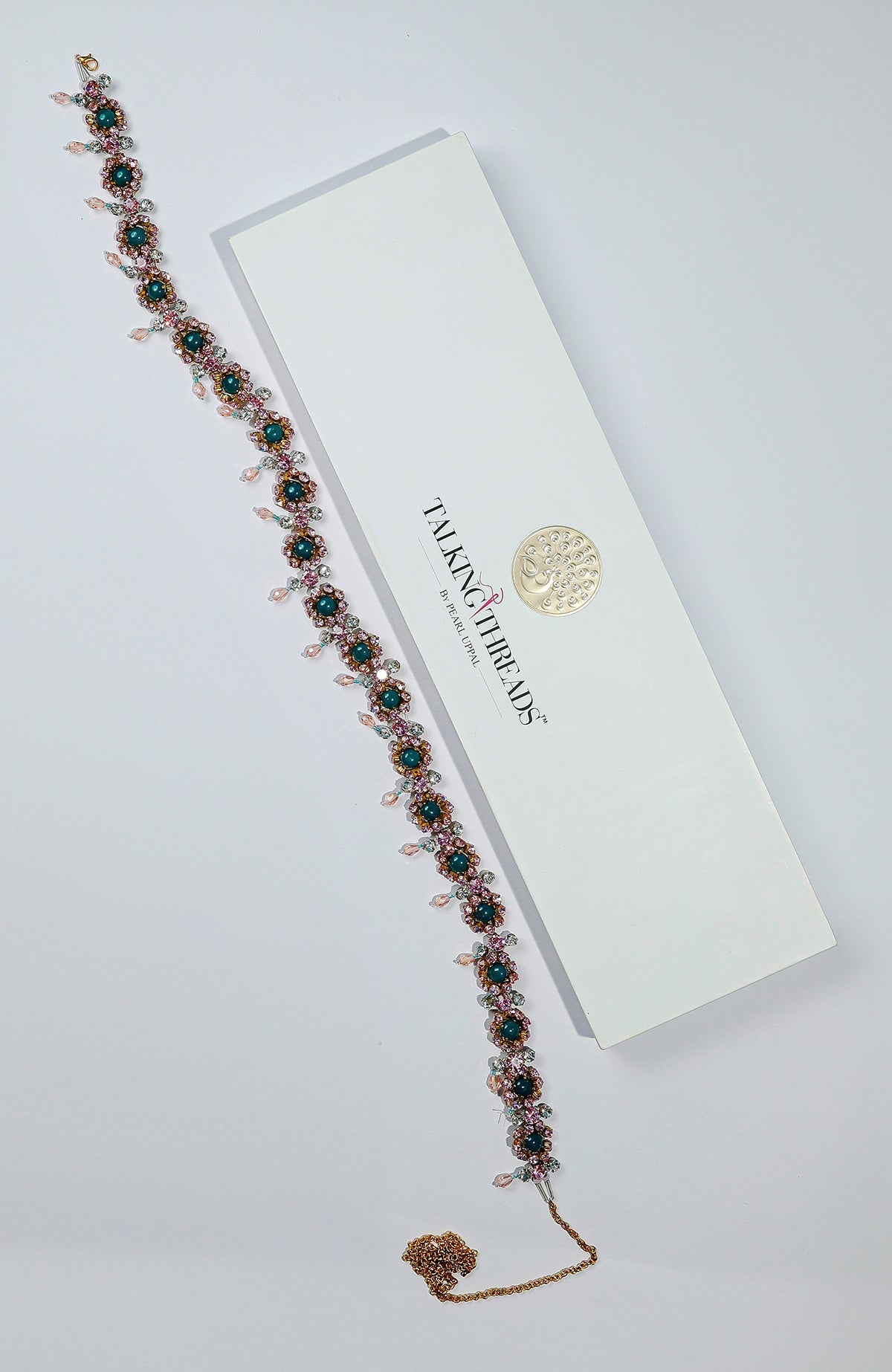 Pink belt adorned with green and pink crystals and golden dangling stones.